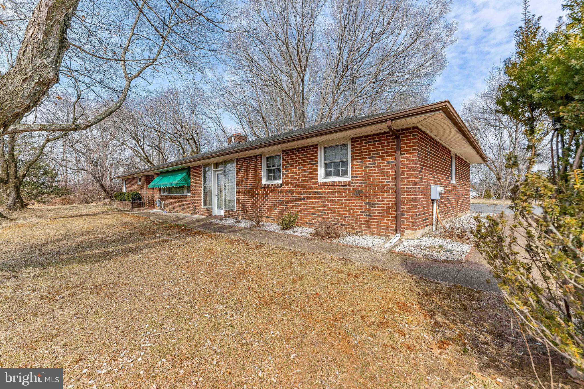 Welcome to 205 Conchester Road, a charming 3-bedroom, 2.5-bathroom brick ranch nestled in the highly sought-after Penns Grant neighborhood of Glen Mills. Set back from the street on a peaceful and serene 2.6-acre lot surrounded by woods, this home boasts a large driveway and a spacious two-car garage, offering both privacy and convenience. As you enter through the foyer, you'll immediately notice the beautiful hardwood floors that flow throughout the house. From the foyer, step into the bright and airy living room, featuring rich hardwood floors, elegant crown molding, and a cozy wood-burning fireplace with a striking stone surround and mantel—perfect for relaxing evenings. Adjacent to the living room, the formal dining room offers hardwood floors, crown molding, and a ceiling light, with a sliding door leading to the private patio, ideal for entertaining or enjoying outdoor meals. Entering the breezeway that is currently used as a family room, which features tile flooring, a bar, wood stove and ceiling fan, providing a comfortable space for everyday living and entertaining. The well-appointed kitchen offers tile floors, a ceiling light, and ample space for a table. A door from the kitchen leads to the spacious covered 44x16 brick patio, making outdoor dining a breeze. The primary bedroom is a peaceful retreat with hardwood floors and a ceiling light, offering a restful space to unwind. The second bedroom also features hardwood floors, a ceiling light, and an en-suite powder room with tile floors for added privacy and comfort. The third bedroom, equally spacious, offers hardwood floors and a ceiling light. A full bathroom on this level includes tile floors and a tub/shower combo. The finished basement adds even more living space to this home. It includes a versatile game room with tile floors and a ceiling light, as well as a full bathroom with tile floors and a stall shower. A dedicated laundry room with tile floors adds convenience, and a bonus room provides the perfect space for a home office or guest bedroom. Additionally, the basement features a kitchenette with tile floors, perfect for entertaining or extended stays. The utility room houses all of the home’s systems, and the water heater was recently replaced in 2024, ensuring peace of mind for years to come. Additionally, the home offers a new holding tank for the water system and a well pump replaced in 2024. This home offers everything you need and more, all within a prime location off Conchester Highway. Enjoy easy access to local shopping, dining, and grocery stores, making daily life both comfortable and convenient. Don't miss the opportunity to make 205 Conchester Road your new home!