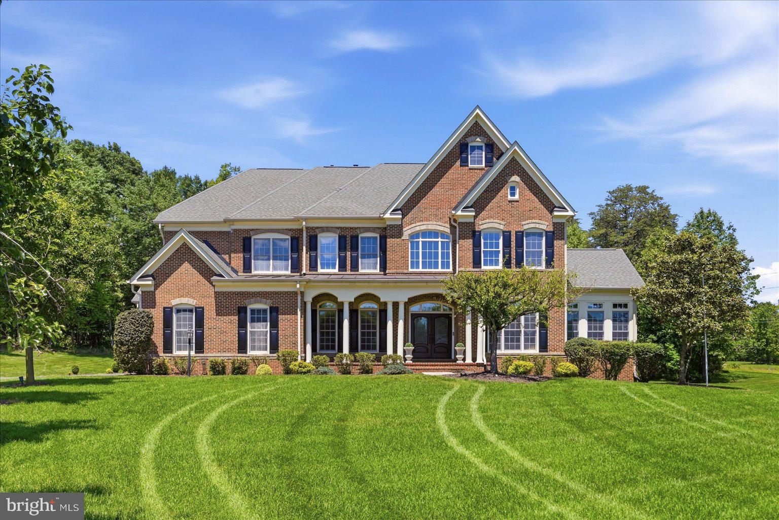 Welcome to this stunning luxury single-family home in the heart of Chantilly, perfectly situated on over 3 private acres and offering more than 7,300 square feet of beautifully updated living space. From the moment you enter the impressive two-story foyer, you are greeted by elegance and sophistication throughout. The main level features formal living and dining rooms, with the dining room leading into a sun-filled sunroom surrounded by walls of windows. Gleaming hardwood floors span the entire main level, complemented by a private office, stylish half bath, and a grand dual staircase with elegant metal spindles.
The expansive family room showcases soaring 14-foot ceilings, a cozy gas fireplace, and seamless flow into the spectacular fully remodeled kitchen completed just two years ago. Designed for both everyday living and entertaining, the kitchen features stainless steel appliances, an oversized 72-inch refrigerator, six-burner range, quartz countertops, updated lighting fixtures, a Butler’s pantry, and an oversized walk-in pantry. The mudroom was beautifully redesigned in 2021 along with an additional updated half bath. A spacious casual dining area and morning room lead directly to a covered porch overlooking the peaceful outdoor setting. Upstairs, each bedroom offers generous space and privacy. Bedroom one features recessed lighting and a fully renovated attached bath updated in 2022/2023. Bedrooms two and three are both oversized with recessed lighting and beautifully remodeled en-suite baths completed during the same renovation period. The upper-level laundry room adds everyday convenience. The luxurious primary suite is a true retreat featuring tray ceilings, recessed lighting, a separate sitting area, private access to a second covered porch, and dual custom walk-in closets with built-in shelving. The spa-inspired primary bath offers the perfect place to unwind. The fully renovated lower level, completed in 2022/2023, was thoughtfully designed with double-insulated ceilings and sound barriers for added comfort and privacy. This incredible space includes a large recreation room with LVP flooring, a second kitchenette with quartz countertops and white cabinetry, a second laundry hookup, a spacious fifth bedroom with an attached updated full bath, and two additional non-legal bedrooms ideal for guests, office space, or flex rooms. A dedicated home gym and an impressive private movie theater elevate the lower level to true luxury living. The theater comes complete with a projector, oversized screen, and immersive surround sound system, creating the ultimate at-home cinematic experience perfect for movie nights, sports events, and entertaining guests. Step outside to enjoy two expansive concrete patios, a fire pit area, and endless open space with plenty of room to add a pool. Surrounded by beautiful private scenery, yet conveniently located just minutes from shopping, dining, major commuter routes, and top-rated schools, this extraordinary property offers the perfect combination of luxury, privacy, and convenience. This is truly a home you do not want to miss! Photos may be virtually staged