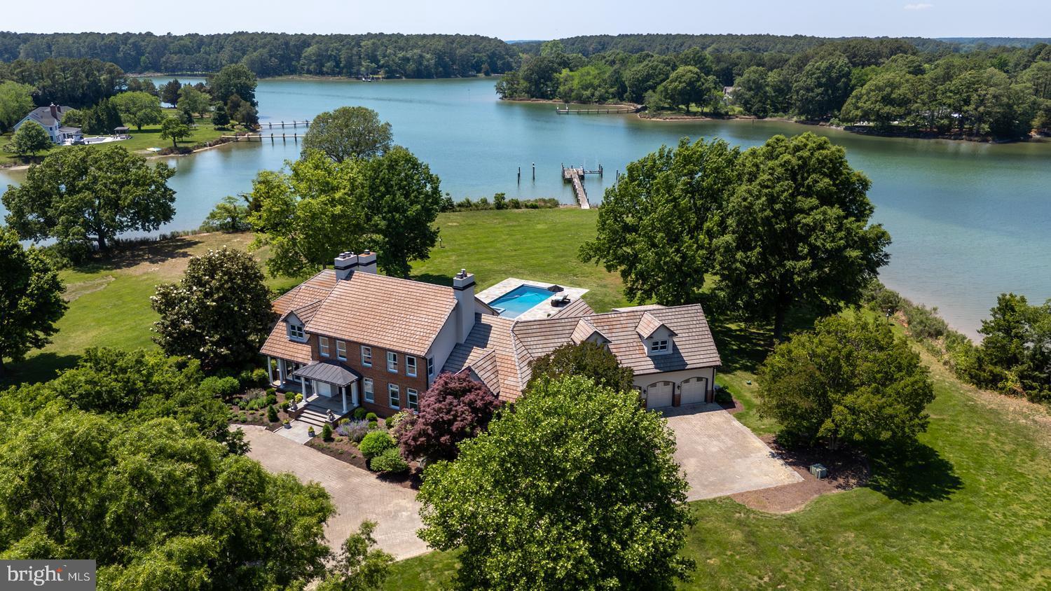 Perfectly nestled on 4.96± private waterfront acres between Easton and St. Michaels, this extraordinary estate embodies the very best of Eastern Shore living, anchored by rare deep water dockage (6’+ MLW) for the ultimate Chesapeake boating lifestyle.  This Royal Oak home’s western exposure offers amazing sunset views across Solitude Creek.This listing also includes a fully prepaid 96-year recorded ground lease on an adjoining 5.48± acre parcel of land -- featuring a picturesque wildflower pasture, a mature 4± acre maple orchard, and charming outbuildings (detached garage and red barn) -- creating unparalleled privacy, beauty, and tranquility.

A winding, tree-lined private drive sets the tone for the peaceful retreat that awaits.  Inside, panoramic water views fill nearly every room, while the recently updated home blends timeless elegance with warm, inviting comfort.  Soaring ceilings, rich hardwood floors, exquisite custom moldings, and expansive living spaces create an atmosphere that is both refined and welcoming.

The formal living and dining rooms, each centered around a cozy fireplace, offer inviting spaces for memorable gatherings and celebrations. The light-filled family room features dramatic volume ceilings, oversized windows, a fireplace, and stunning waterfront views that bring the outdoors in.

Designed for both everyday living and effortless entertaining, the gourmet kitchen features slate flooring, stainless steel appliances, a walk-in pantry, and a waterside breakfast area where every meal is paired with breathtaking scenery.

The luxurious main-level owner’s suite is a private sanctuary with its own fireplace, spectacular water views, dual walk-in closets with custom built-ins, and a spa-inspired bath designed for relaxation. Upstairs, guests and family are comfortably accommodated with a spacious bedroom suite, two additional guest bedrooms, and a versatile bonus room ideal for a home theater, fitness studio, or playroom.

Above the oversized, air-conditioned three-car garage, a separate guest retreat with a kitchenette, full bath, and private balcony with beautiful waterfront views offers the perfect space for visiting friends and family.

Outdoor living is equally exceptional. A sprawling slate patio, recently added waterside pool, and enclosed porch with vaulted ceilings and flagstone flooring create inviting spaces to relax, entertain, and take in the serene surroundings. Set on a peninsula with more than 1,000 feet of shoreline, the property offers remarkable privacy and endless water views in seemingly every direction.

A private deep water pier on Solitude Creek makes boating effortless and permits a memorable arrival by water for your guests.  Enoy fishing and crabbing and direct water access to the Choptank River and Chesapeake Bay. Rarely does a property so gracefully combine timeless architecture, resort-style amenities, and one of Talbot County’s most coveted waterfront settings into a place that truly feels like home.