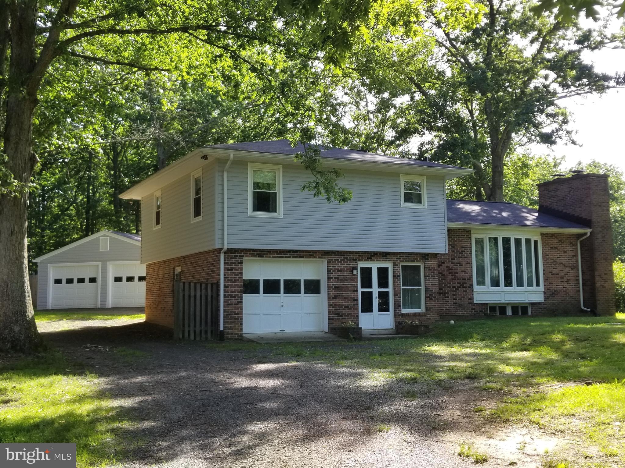 AWESOME LOCATION!  NO HOA!  This unique  home has undergone several updates in the past few months and awaits its new owners!  New siding, new roof, new HVAC, new bath, updated kitchen with stainless appliances and granite tops, living room and family room with fireplaces, dining room, 3 BR's on upper level with large bath.  Enjoy the stone patio out back with stone fireplace for entertaining.  Attached garage plus detached 24'x32' garage.  Nice trees surround home to keep it cool in the summer time!
