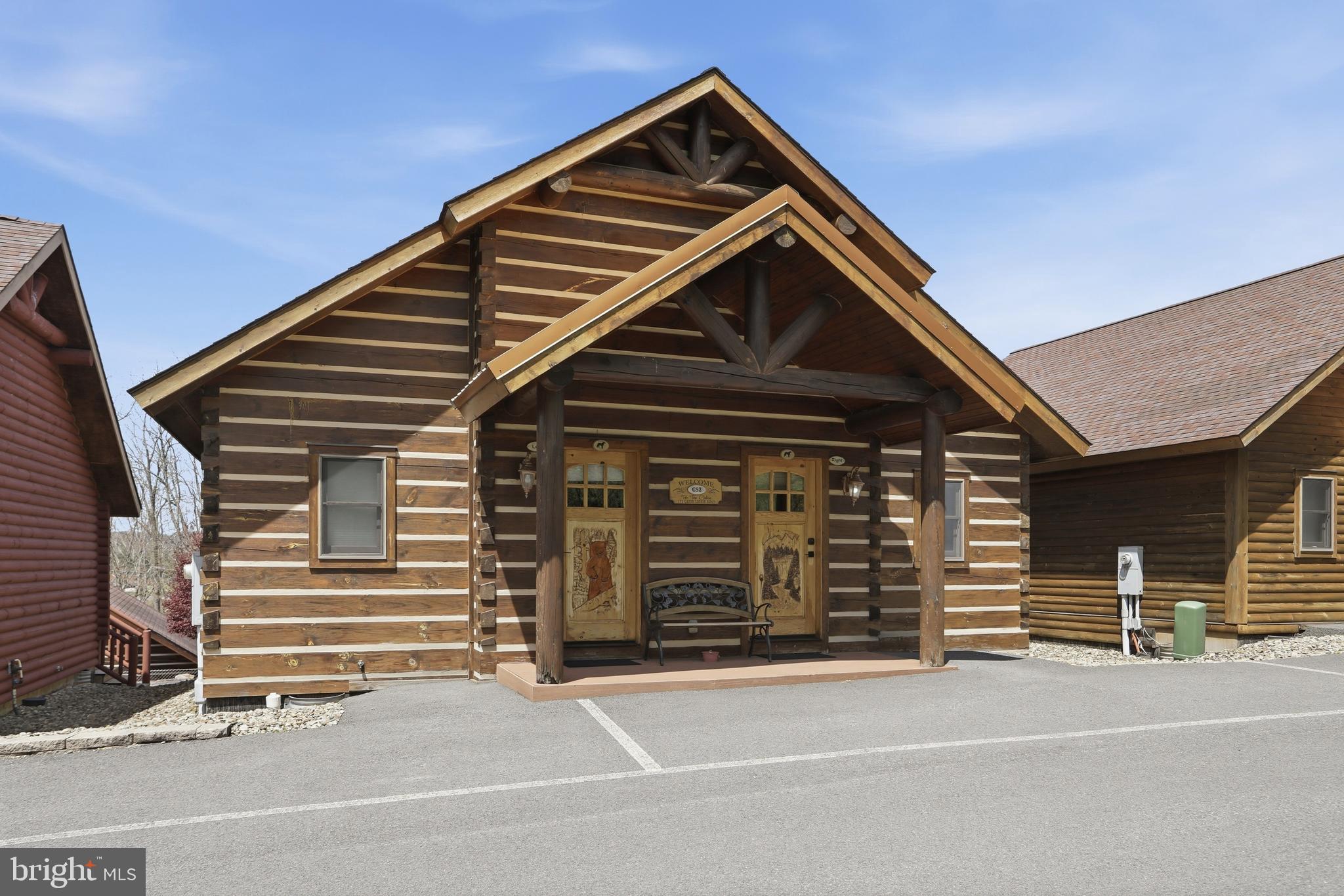 BOAT SLIPS! LAKE ACCESS & VIEWS! 4TH OF JULY FIREWORKS VIEWS! SKI SLOPE VIEWS! Cabin #52 at The Lodges of Sunset Village is a detached home offering two "lock off" units with a shared door between the units. Each side offers an efficiency-style layout on the main floor with a kitchenette, and a full bath. One side has a king bed and full bath with a jetted soaking tub and huge walk-in shower, and the other side has a queen bed, twin bunk beds, a full bath, and both units have a kitchenette. This unit also has a deck and patio. 10.24% GROSS REVENUE YIELD with a PROVEN  RENTAL HISTORY GENERATING AN AVERAGE OF $70,152 IN ANNUAL GROSS RENTAL INCOME over the last FIVE YEARS.

Rich in mountain character and charm, this log cabin features uniquely carved wood doors, beautiful beamed ceilings, warm wood walls, and inviting spaces that create an authentic lake and mountain retreat feel. Additional features include lake views, ski slope views, expansive decks and patios, upgraded finishes, open concept living, stacked stone gas fireplace, and open concept living.

Enjoy incredible views of Deep Creek Lake and Wisp, along with front row seats for seasonal beauty and memorable moments, including views of the annual July 4th fireworks. This is an exciting opportunity for buyers seeking both personal enjoyment and investment potential.

Experience one of Deep Creek Lake’s newest ownership opportunities at The Lodges at Sunset Village. For the first time ever, fully furnished lake area cabins are being offered for individual ownership in a breathtaking community featuring incredible lake and Wisp ski slope views. Community amenities include lake access with 10 shared dock slips and an impressive 1,320 square foot waterfront dock area perfect for fishing, swimming, launching kayaks, relaxing by the water, and enjoying summer fun at the lake. Residents and guests also enjoy a lakeside gazebo, playground, fire pit, gathering areas, pet-friendly accommodations, abundant parking, and on-site professional management.

The monthly condo fee provides exceptional convenience, including most utilities, snow removal, trash service, and yard maintenance, for a low-maintenance ownership experience. Whether you're searching for a vacation retreat, income-producing investment, or both, The Lodges at Sunset Village offers a rare opportunity to own at Deep Creek Lake. Owner financing options may be available. 

Call today for details and your private showing!