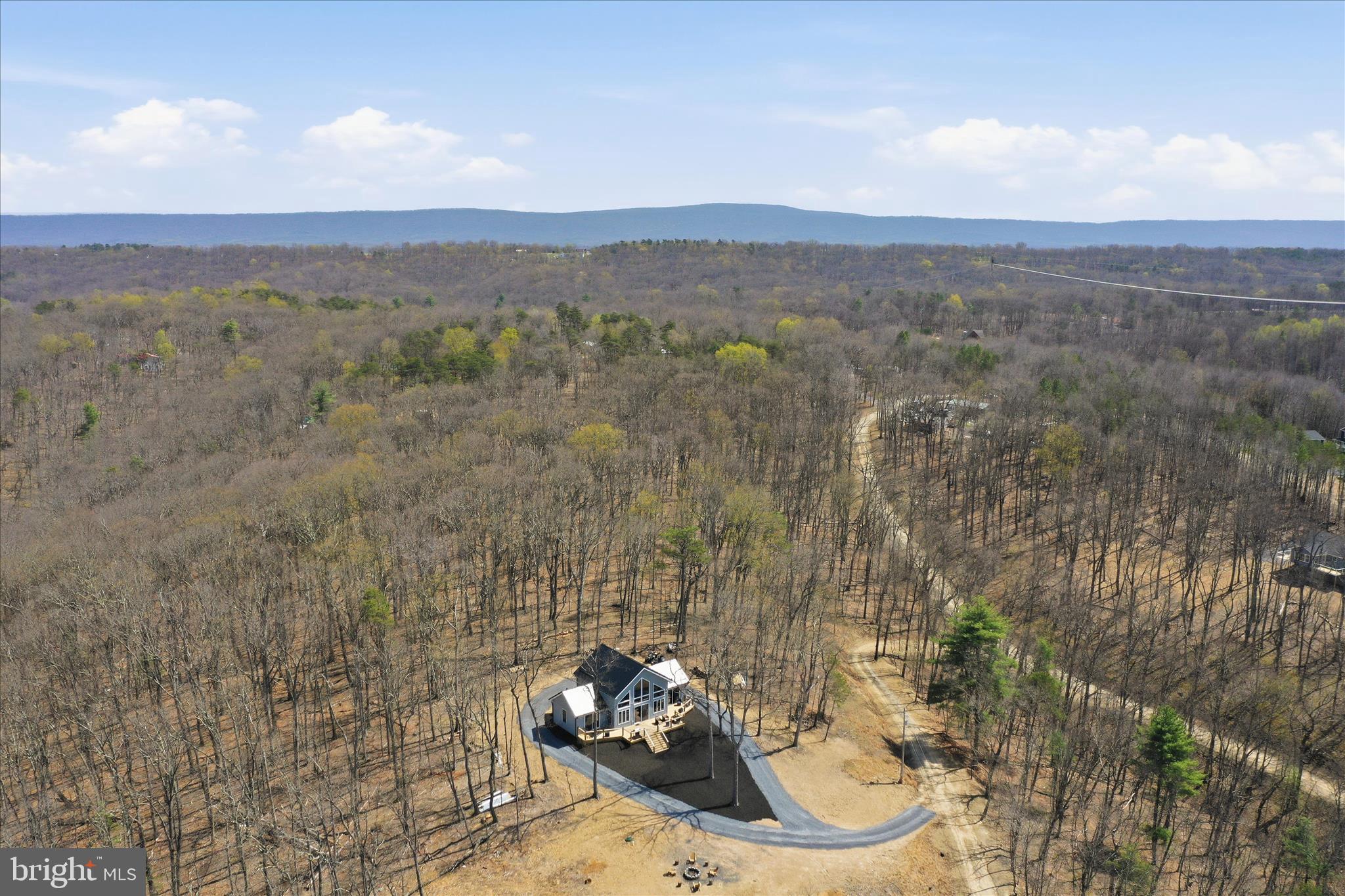 Some homes have a view… and then there are homes like 432 Lost Point Lane where EVERY room feels like a front-row seat to West Virginia beauty. Imagine waking up to breathtaking scenery, sipping your morning coffee while soaking in mountain views, and ending your evenings watching the sunset from the comfort of home. This is more than a house — it’s the lifestyle people dream about. From nearly every window, nature steals the show and creates the peaceful retreat you’ve been searching for. Whether you’re looking for a full-time home, mountain escape, or investment opportunity, this one is truly unforgettable. Trust me… the photos are stunning but seeing it in person is a whole different experience. 
Imagine waking up every morning to the views this home provides! Set on over 2 acres, 432 Lost Point Lane in Berkeley Springs, West Virginia offers a setting that feels private and connected to the landscape, with panoramic vistas that are rarely found. Wanting a true West Virginia Mountain getaway that is newly constructed with upgrades to match? Keep reading!  Built in 2025, this custom home blends craftsmanship with thoughtful design across approximately 1,900 square feet. Wood flooring runs throughout, complemented by custom tiled showers and a well-appointed kitchen featuring high-end appliances, including an adjustable waterfall faucet at the sink with all the bells and whistles. Built with top-tier insulation, the home supports comfort and efficiency in every season. A standout feature is its ADA-compatible design—an uncommon find in today’s market—featuring wider doorways, lever-style handles, tilted mirrors, and a roll-in tiled shower, all seamlessly integrated into the home’s layout. Two main-level primary suites each include full baths, offering a balanced and functional design. An additional full bath in the loft bedroom #3 provides added flexibility. There is no part of this home that has not captured the views! When you close the doors to the bedrooms, you are still blessed with amazing views and access to the massive front deck. The home is fully furnished, creating a turnkey opportunity from day one. Just move right in! Enjoy community water access just moments from your doorstep—perfect for fishing, kayaking, and relaxing by the water. Located less than two miles from Cacapon Resort State Park, with easy access just 6 miles to the Virginia line and a short drive to historic Berkeley Springs, this location offers both recreation and convenience.
. Every detail supports a lifestyle centered on ease, comfort, and the surrounding view. Book a showing today! This one is a rare find in this market and is ready for you to call home!