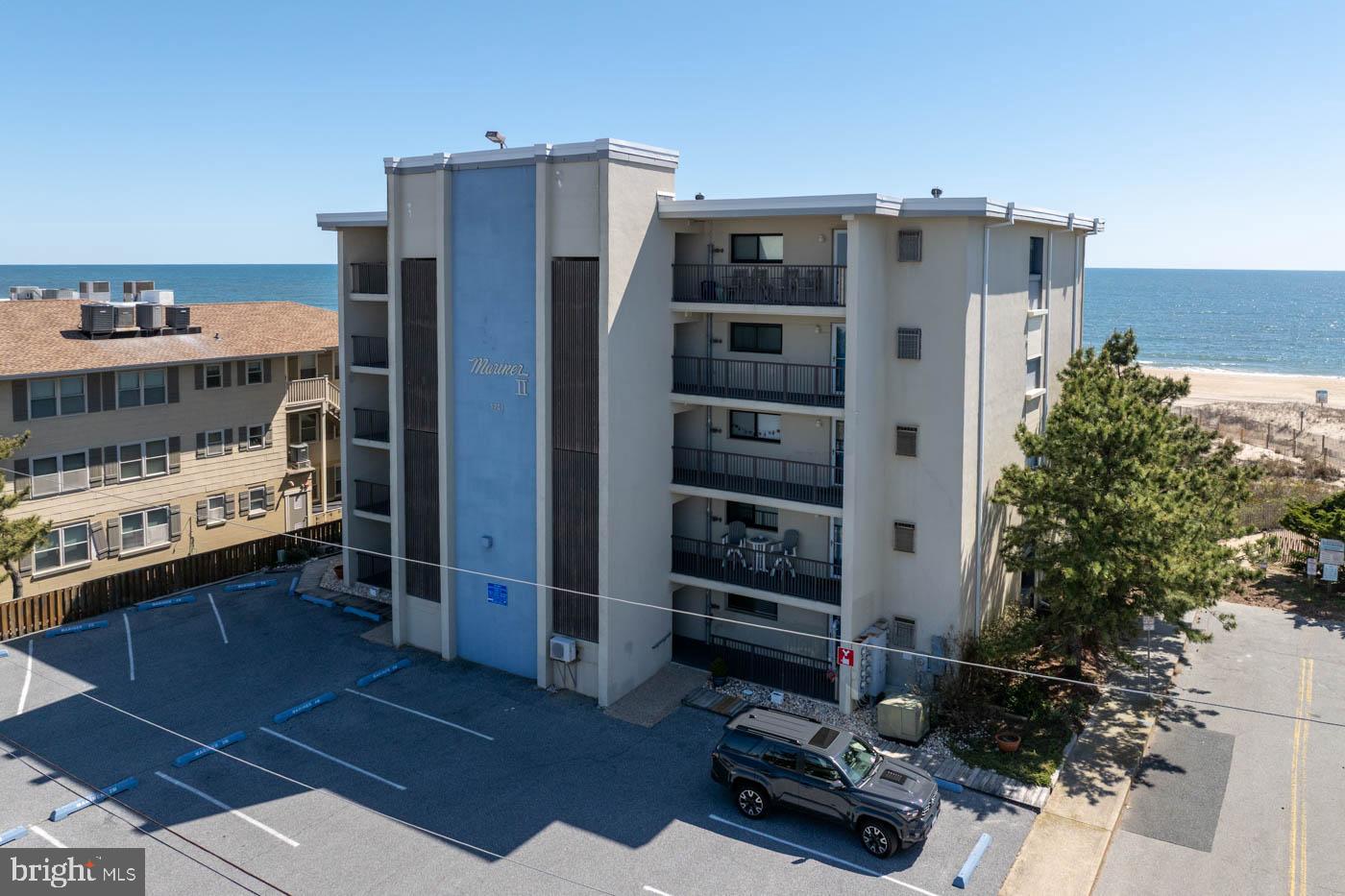 Direct oceanfront at Mariner II with a covered walk-off balcony and a private sand path through the dunes — step off the balcony, take a few steps, and you are on the beach. No shared elevator or interior stairs between the unit and the sand.

Offered fully furnished and turnkey. No prior rental history — owner-used only — and ready to step into rental rotation if that is the plan.

Interior is fully updated. Living and dining are open to each other and to the kitchen, with a full shiplap wall behind the sofa. White kitchen has stone counters, subway tile backsplash, and a peninsula bar. Light flooring runs through the main living areas. Wide sliders frame the dune view and pull natural light deep into the room.

Primary suite features a king bed and a fully updated ensuite — vertical-tile walk-in shower with glass enclosure, custom built-in niches, wood-look vanity with quartz top, and matte black framed mirror. Dune views from the bedroom window.

Second bedroom is configured with two queens — sleeps four in that room. Room for the entire family and friends!

Second full bathroom with tub-shower combination serves the guest bedroom and main living spaces.

Covered balcony with seating overlooks the dunes and beach. Assigned parking space plus unassigned overflow. Outside Shower as well!

Move-in ready. Use as a primary residence, second home, or rental property.