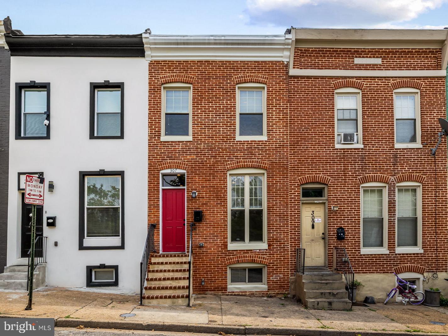 Welcome to 307 Font Hill Avenue, a top-to-bottom fully updated townhome tucked away on a quiet dead-end street. This home blends modern upgrades with classic Baltimore charm, featuring luxury vinyl plank flooring, exposed brick accents, and recessed lighting throughout. The main level offers a large living room, half bath, laundry closet, and a gourmet eat-in kitchen complete with granite countertops, stainless steel appliances, and ample cabinet space. Step directly from the kitchen onto a large rear deck that overlooks a fully fenced patio, perfect for entertaining or relaxing outdoors. Upstairs, you will find two spacious bedrooms with great natural light and a centrally located full bathroom. The finished lower level provides excellent flexibility with an additional bedroom, full bathroom, and a comfortable family room space. Recent updates include fresh paint throughout, new carpeting, and updated flooring, making this home truly move-in ready. Easy street parking adds everyday convenience. Located adjacent to the SEED School and the Gwynn Falls Trail, this home offers access to both nature and community. Enjoy an active neighborhood atmosphere with a yearly summer block party and shared community gardens that bring neighbors together.