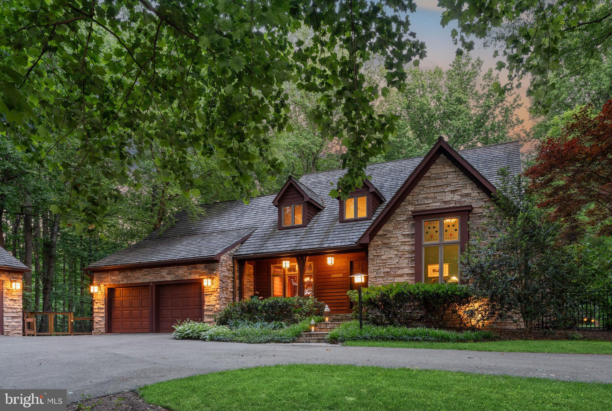 A rare offering where craftsmanship, landscape, and daily living remain thoughtfully connected. Set within 3.8 private acres in Marriottsville, this Arts and Crafts-inspired residence was designed not to dominate its surroundings but to become part of them. Stacked stone, warm woods, and a cedar shake anchor while carefully placed windows frame seasonal views in every direction.

Custom stained-glass transoms are inspired by surrounding flora. Hardwood floors, sky lights, solid oak doors with hammered iron and glass hardware, stacked-stone fireplace are pure artistry and texture. Privacy and easy living with main floor primary suite, generous bath with soaking tub, and beautiful garden views. 

Tiered Brazilian mahogany decking extends living space and connects via mudroom, kitchen and great room. Expansive and intimate space for dining and lounging, an outdoor kitchen area with a 2025 Lynx Grill, views of perennial gardens and specimen trees. Through the garden gate a bluestone terrace holds a spa and freeform saltwater pool with boulder waterfall, and convenient pool house with outdoor shower.

Whole house generator, additional detached garage, Telsa EV charger. An off grid feel yet within 10 minutes of I-70, Turf Valley Towne Center and Resort, Harris Teeter, golfing and spa days. Under 15 minutes to Historic Sykesville, Patapsco Valley State Park trails, Historic Ellicott City, Howard County Fairgrounds. Baltimore’s Harbor East shopping and restaurants and BWI Airport/AMTRAK in 35-40.