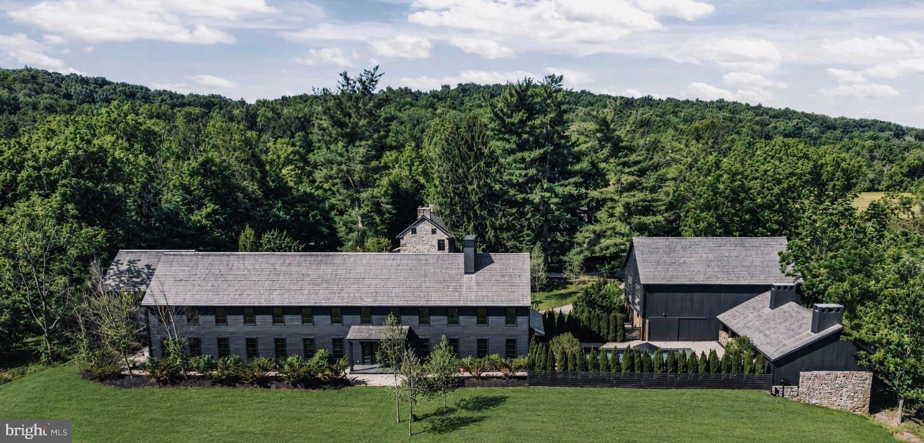 La Maison Noir is a bespoke luxury estate conceived as a celebration of nature, craftsmanship, and hospitality. Set within a private farm landscape just 70 minutes from Manhattan and 60 minutes from Center City Philadelphia, the property unfolds as a collection of architecturally distinct structures connected by gardens, meadows, and winding estate roads. The personal residence of Patrick Pastella and Kanitha Burns, founders of PASTELLA | BURNS, the estate was envisioned without compromise as a once-in-a-generation retreat where design, landscape, and hospitality exist in perfect harmony. The property encompasses a modern primary residence featuring a private wellness spa, sauna, wet room, media room, and expansive entertaining spaces; an 18th-century stone farmhouse with luxury guest accommodations, wine cellar, and martini lounge; a historic carriage house and well house; a contemporary garage pavilion with a private office suite; a dramatic timber whiskey barn complemented by a fire-cooking outdoor kitchen and sunken lounge; and a resort-style pool framed by a lush garden courtyard. La Maison Noir is offered fully furnished, including every custom-designed REVERIE interior, fixture, furnishing, and signature element created exclusively for the estate. Further distinguishing the property is its extraordinary level of craftsmanship and customization. Nearly every interior detail, including wall paneling, flooring, kitchens, vanities, built-in furnishings, doors, steelwork, lighting, and bespoke furniture, was conceived and fabricated specifically for La Maison Noir in collaboration with REVERIE. More than a residence, La Maison Noir is a private sanctuary thoughtfully curated to create an experience unlike any other, a place where exceptional design, natural beauty, and meaningful gathering come together as one.
Living Space Summary: 
New Main Luxury Residence with spa, gym, media room 6600 sq ft,
Renovated Historic Stone House Guest Residence, lounge, bar, wine cellar 1600 sq ft,
New Detached Studio Garage Finished office/studio above garage 660 sq ft,
Renovated Historic Timber Barn, hospitality space, outdoor kitchen 6600 sq ft,
Renovated Historic Stone Carriage House structure and storage 400 sq ft,
Historic Stone Well House 200 sq ft,
This totals 15,460 sq ft.