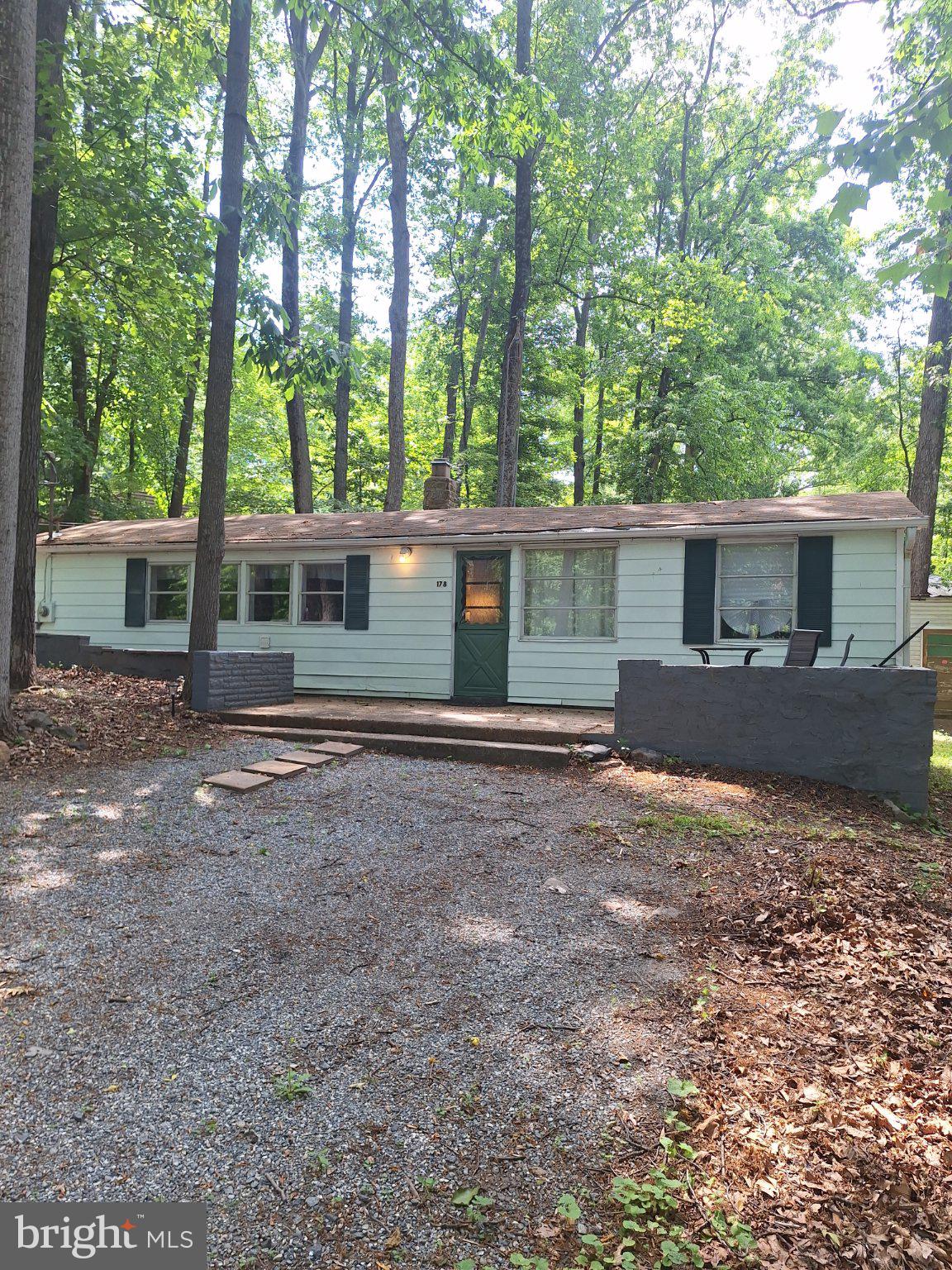 Solid long or short term rental or retirement home just one block off the lake on .31 ac.  wooded lot (no grass to mow). No HOA, no water/sewer bills, Comcast internet available. Small space, but with character; cathedral ceilings, stone fireplace and exposed logs. Includes many new upgrades; very efficient mini-split heat pump, new paint inside and out, new bath fixtures, water heater, refrigerator.