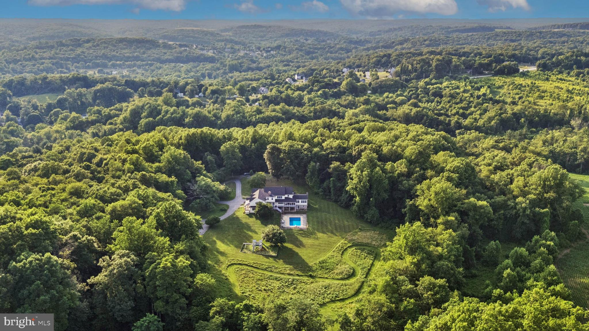 ESSENCE
Live authentically. Hereford zone oasis. Framed by striking natural rock outcroppings, this 18.61 acres offers the freedom and lifestyle you have been craving. Endless exploring through rolling meadows with trails and small streams. A rambling farmhouse that meets all of your needs for space. Walls of glass beckon you to the great outdoors. A house for living. A multitude of porches for every season. Epic mudroom. A two-story great room, anchored by a soaring stone fireplace. Four fireplaces. Finished lower level that serves as a pool house within the house. Take a dip under the stars, or gather around a fire and hunt for the perfect roasting stick. Fireflies galore. The detached garage offers exceptional flexibility, with two separate access points — one bay featuring three garage doors and a second heated and cooled area ideal for a workshop. A chicken coop with electricity sits conveniently near the driveway for easy morning egg collection, alongside an additional storage shed. Embrace the country lifestyle while being minutes to everywhere you want to be. Verizon 5G Internet. Cultivate your existence. The art of uniting human and home.

LOCAL FLAVOR AND PROVISIONS
Graul's Market along with favorite local dining at Casa Mia’s, Milton Inn, Manor Tavern, Butlers Tavern, The Fill'Er-Up, The Yellow Barn, Woodfire Kitchen and The Creamery Connection. Tap into local breweries, such as Inverness Brewing, Farmacy Brewing and Big Truck Farm Brewery.

OUTINGS AND LEISURES
Explore the NCR Trail. A 21-mile flat, crushed-stone trail open to hikers, bikers, and horses, it runs along the scenic Gunpowder Falls river. Minutes to Prettyboy Reservoir. This area is open to hiking, rowing, or paddle boating, bird watching, horseback riding and nature photography year-round, and for archery hunting during a regulated season. Go tubing on the Gunpowder River. Enjoy Ladew Topiary Gardens... these gardens are 22 acres of spectacular, award-winning gardens, more than 100 remarkable topiaries, a mile-long Nature Walk, and native Butterfly House. Explore The Manor Mill, a pre-revolutionary grist mill that now houses a wide variety of art and entertainment events. Tee off at Greystone Golf Course in White Hall.

PROXIMITY
Zippy access to the I-83 on ramp, about 17 minutes to Hunt Valley, and about 27 minutes to Towson. 60 minutes to BWI and 31 minutes to Penn Station.

REGION
The Hereford Zone is a protected, rural area, covering roughly 20% of the county's land area. The community was historically centered on agriculture and still maintains that charm today.