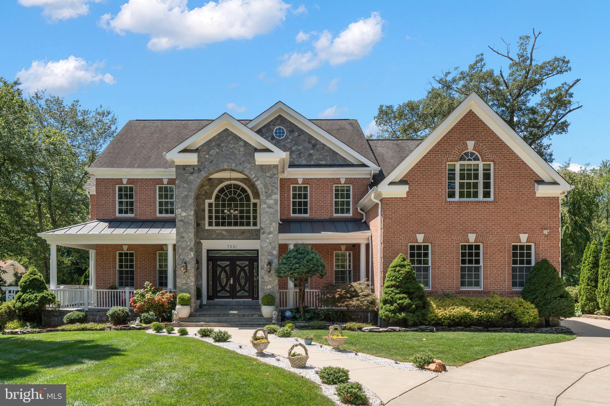 Welcome to 7331 Calvert St—an exceptional custom-built estate offering refined luxury, thoughtful design, and over $100,000 in recent performance and wellness upgrades (see a full list in Documents section). Perfectly positioned on a quiet street, this rare opportunity features nearly one acre inside the Beltway, blending privacy, space, and convenience in an unparalleled location.
From the moment you arrive, the limestone-covered wraparound front porch welcomes you, overlooking manicured grounds and curated plantings. The level, professionally designed lot showcases expansive patios, beautiful lawn and flower beds, and a 9-zone irrigation system to keep everything pristine year-round.
Inside, substantial craftsmanship meets modern functionality. Built with 2×6 framing, 10-foot ceilings, Brazilian hardwood floors, detailed millwork, Schonbek chandeliers, iron railings, dual staircases, and three gas fireplaces, the home reflects substantial construction quality rarely found in newer builds. Modern infrastructure includes 3-zone HVAC with smart thermostats, security system with 12 exterior cameras and smart CO detectors, a 400-amp electrical system, two EV chargers, and a professionally serviced whole-house generator for ultimate peace of mind.
Elegant formal living and dining rooms create memorable entertaining spaces, with the dining room beautifully encased in windows. A main-level office provides privacy for work or study. The stylish butler’s pantry— complete with a mini-fridge and wine refrigerator —adds practical preparation and storage space. Connected is a charming tea room with heated floors, paired with a social kitchen, provides direct access to the patios for effortless indoor-outdoor entertaining.
The gourmet kitchen is designed to inspire, featuring a Viking Professional 6-burner gas range, pot filler faucet, custom tiled backsplash, deep pantry, and an oversized island perfect for gathering and meal preparation. The adjacent two-story family room stuns with a dramatic coffered ceiling, fireplace centerpiece, and walls of windows that flood the space with natural light. A spacious sunroom extends the living area and provides a bright retreat you’ll cherish year-round. Two conveniently located powder rooms complete the main level.
Upstairs, the luxurious owner’s suite features a gas fireplace, private sitting room with heated floors, generous walk-in closet, and spa-inspired bath with dual vanities, soaking tub, and expansive glass shower with Rohl hardware. Three additional bedrooms each include en-suite baths. A second primary suite offers its own sitting room, bedroom, and private bath with Jacuzzi tub — ideal for guests or multi-generational living. The laundry room is conveniently located on the bedroom level.
The walk-out lower level features a large recreation room, built-in bar, gas fireplace, theater room with soundproof walls, spacious bedroom with a wall of mirrors, full bath, and luxurious dry sauna—creating a true in-home retreat. Double doors open to a wide staircase, providing plenty of natural light and easy access to the patios for entertaining.
Outdoors, the expansive backyard offers a peaceful private paradise—perfect for gardening, grilling, play, and al fresco dining on the patios. A heated 3-car garage protects your vehicles year-round and completes this extraordinary offering. 
Ideally located just 30 minutes to Dulles Airport, 17 minutes to Reagan National, 5 minutes to VRE, and 12 minutes to Metro, this home delivers exceptional access while remaining tucked away in one of the most desirable Beltway locations. Grocery stores, shopping, dining, and daily conveniences are all within minutes. Square footage per builder’s plans and includes the garage.
A rare combination of elegance, scale, resilience, and location — this is refined living without compromise.