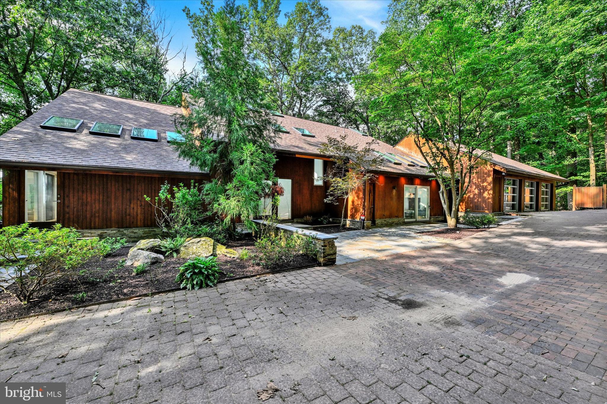 This expansive, contemporary home offers a truly remarkable opportunity in the Garden View community of Pikesville. Situated on over 4 private acres featuring stunning and expansive wooded views from each window throughout.  As you approach the home through your private gated entrance at the end of the community, you will notice the sprawling estate layout.  The property offers six bedrooms and six total bathrooms across nearly 7,000 square feet of finished living space. Luxury living at it's finest, with a combined 7 car garage, an impressive pool house, heated pool, and multiple deck and patio options that offer a fire pit and more.  An entertainers dream! 

The main level includes well designed living and dining areas, cathedral ceilings, a chiefs kitchen with a  large island, high end appliances and a central facing sink and cook top.  Further down the hallway a complete wellness area will greet you as you enter the far side of the home that includes a fitness room, a sauna and separate steam room with a cool down space to relax afterwards.  

The lower levels provide a flexible layout with additional bedrooms along with common family and entertaining spaces.  Expansive ceiling height combined with the elegant spiral staircases, provide a glimpse into the designers vision of a grand experience.  

The primary suite continues the theme and offers a custom fireplace, 2 walk-in closet spaces, and en-suite bathroom with views from every angle. The floor-to-ceiling windows throughout bring in natural light and the surrounding landscape in a way that must be seen in person to appreciate fully.   

Outdoor living is a true highlight, with a heated in-ground pool (brand new heater), hot tub, expansive deck, and a separate pool house offering a full kitchen, bedroom and full bath complete with separate laundry.

The 7 garage spaces include a three-car attached garage and a four-car detached garage, offering ample storage and workspace for even the most ambitious of auto enthusiasts. Located just minutes from commuter routes, shopping, and dining in Pikesville/Baltimore, this home combines privacy, space, and convenience in one exceptional property.  Schedule your tour today as an opportunity like this does not come around often!