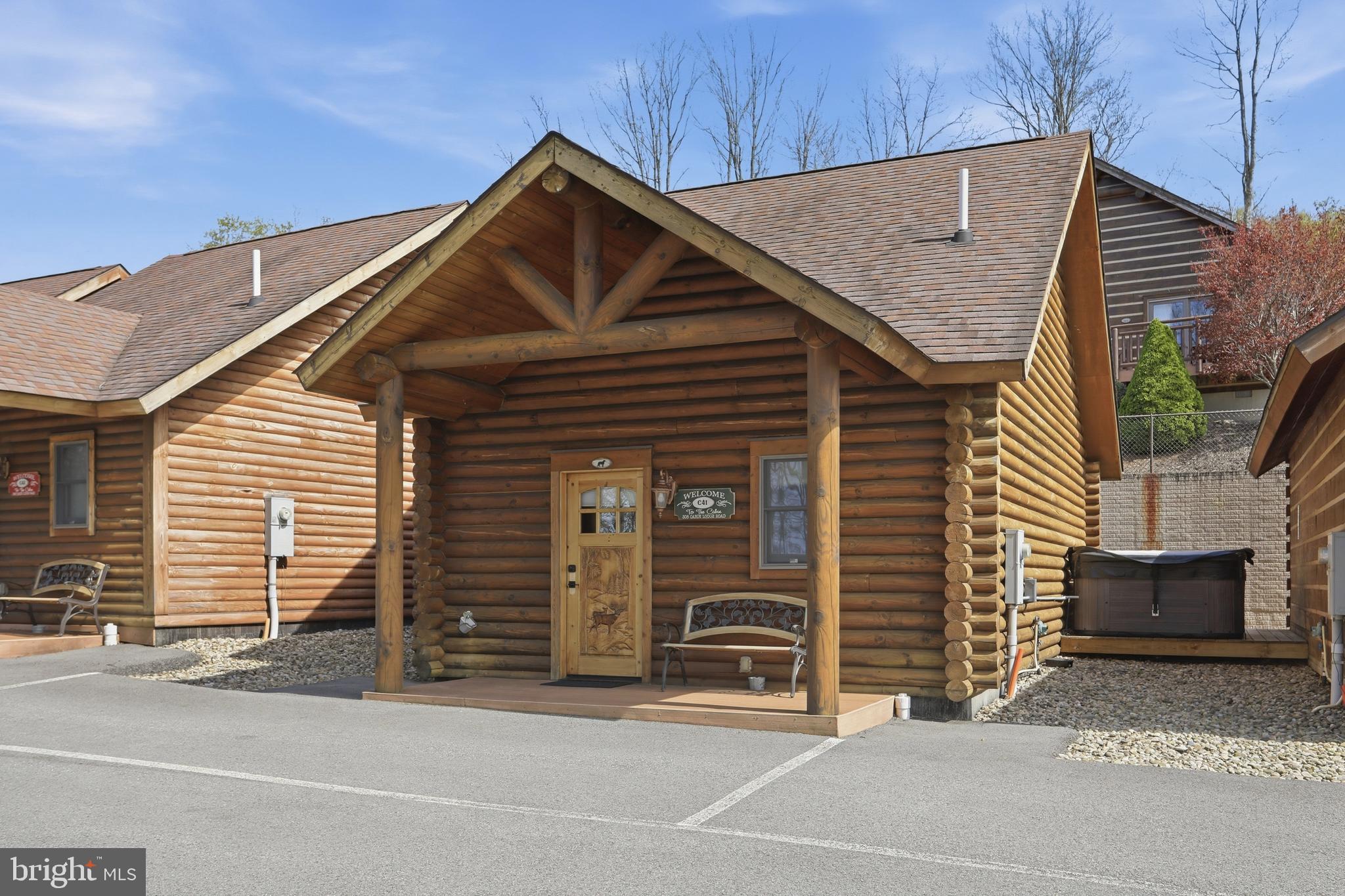 BOAT SLIPS! LAKE ACCESS & VIEWS! 4TH OF JULY FIREWORKS VIEWS! SKI SLOPE VIEWS!  Cabin #41 at The Lodges of Sunset Village is a detached unit with two queen beds, a full bath, and it's fully furnished and turnkey. This unit has a porch, a patio, and a hot tub, too! This cabin also has a hookup for a washer and dryer! 

10.65% GROSS REVENUE YIELD with a PROVEN  RENTAL HISTORY GENERATING AN AVERAGE OF $34,614 IN ANNUAL GROSS RENTAL INCOME over the last FIVE YEARS with an AVERAGE of 104 DAYS RENTED annually for an ADR of $333.

Rich in mountain character and charm, this log cabin features uniquely carved wooden doors, beautiful beamed ceilings, warm wood walls, and inviting spaces that create an authentic lake-and-mountain retreat feel. Additional features include lake and ski slope views, expansive decks, upgraded finishes, open-concept living, a stacked-stone gas fireplace. Enjoy incredible views of Deep Creek Lake and Wisp, along with front row seats for seasonal beauty and memorable moments, including views of the annual July 4th fireworks. 

This is an exciting opportunity for buyers seeking both personal enjoyment and investment potential. Experience one of Deep Creek Lake’s newest ownership opportunities at The Lodges at Sunset Village.
and Wisp ski slope views. Community amenities include lake access with 10 shared dock slips and an
impressive 1,320 square foot waterfront dock area perfect for fishing, swimming, launching kayaks,
relaxing by the water, and enjoying summer fun at the lake. Residents and guests also enjoy a lakeside
gazebo, playground, fire pit, gathering areas, pet-friendly accommodations, abundant parking, and on-site
professional management. The monthly condo fee provides exceptional convenience, including most
utilities, snow removal, trash service, and yard maintenance, for a low-maintenance ownership experience. Whether you're searching for a vacation retreat, income-producing investment, or both, The Lodges at
Sunset Village offers a rare opportunity to own at Deep Creek Lake! Call today for your private showing!