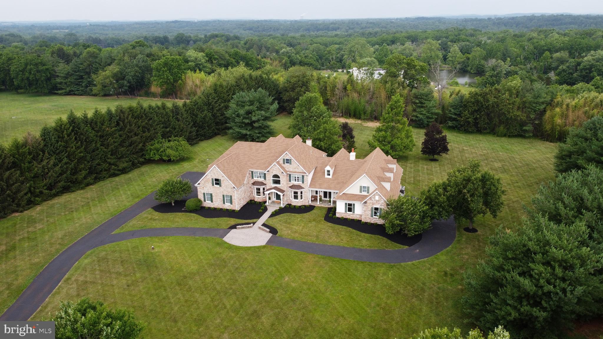 Welcome to this extraordinary estate in Collegeville, located within the highly acclaimed Methacton School District. Situated on 3 private acres, this impressive 4-bedroom home offers 3 full bathrooms, 3 half bathrooms, exceptional living space, and endless possibilities for entertaining, recreation, and luxury living.

From the moment you enter, you'll appreciate the beautifully finished hardwood floors adding warmth and timeless elegance. The main level is designed for both grand entertaining and everyday comfort, featuring a spectacular ballroom complete with a fireplace and custom bar—an ideal setting for hosting celebrations, holiday gatherings, and special events. Two dining rooms provide flexibility for formal entertaining or casual family meals, while the expansive living room showcases soaring 20-foot ceilings that create a bright, open, and dramatic atmosphere.

The upper level is highlighted by an impressive owner's suite that serves as a private retreat. This expansive space includes a separate sitting room, a luxurious en-suite bathroom, and a large walk-in closet. Three additional generously sized bedrooms and two additional full bathrooms—one private and one shared—complete the second floor.

The finished lower level offers an incredible amount of additional living space and is equipped with heating, air conditioning, and a half bath, making it ideal for a home theater, fitness center, game room, home office, or multi-generational living.

Outside, the property's 3-acre setting provides ample room for outdoor entertaining, recreation, gardening, or future expansion. Car collectors, hobbyists, and those needing extensive storage will appreciate the six garage bays, offering abundant space for vehicles, equipment, and workshop needs.

This remarkable property combines luxury, space, and versatility in one of Collegeville's most desirable locations, creating a truly unique opportunity to own an exceptional home.