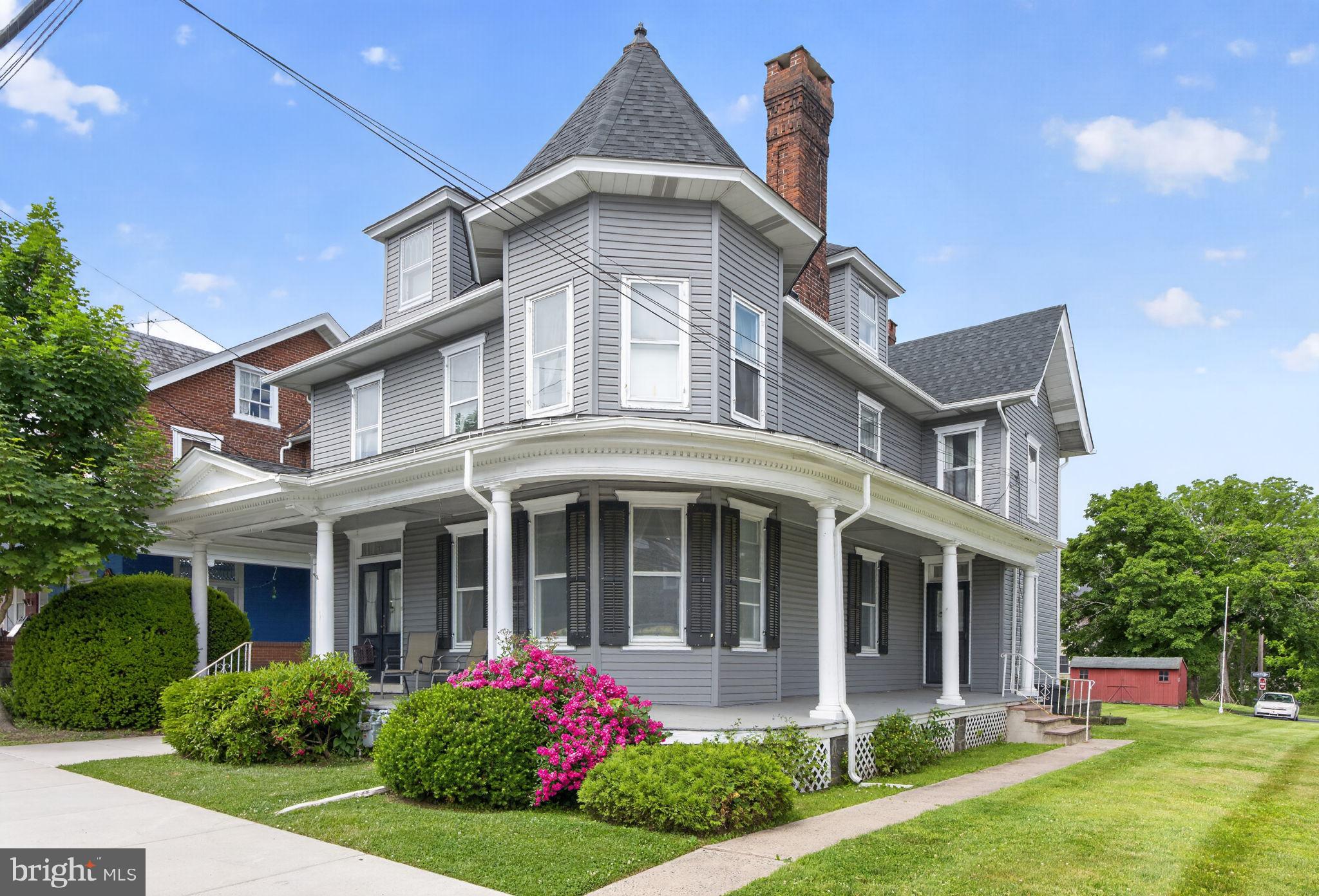 Spacious three-story Victorian Colonial in Southern Lehigh School District offering over 2,800 square feet of living space with 5 bedrooms, and 2 full baths. Recent improvements include a newer roof and vinyl siding, while the remainder of the home offers an opportunity for updates and restoration. A welcoming wraparound porch leads to an impressive reception hall with flagstone flooring. Pocket doors open to the parlor/living room featuring the home's distinctive Victorian turret, wood-burning fireplace, and abundant natural light. An adjoining 290+ square-foot family room showcases an original built-in china cabinet and provides flexible living or entertaining space. Original woodwork and period details are found throughout. The spacious eat-in kitchen offers ample cabinetry and counter space, along with direct access to the covered rear porch, patio, and wraparound side porch. Laundry room / full bathroom combo with a walk-in-tub is conveniently located on first level. Two separate staircases provide convenient access to the upper levels, including a grand staircase from the reception hall and a secondary staircase from the kitchen. The second floor includes four bedrooms, a full bath, and generous closet space. The finished third floor offers a large fifth bedroom or flex space with a walk-in closet and access to an expansive unfinished attic providing excellent storage or future expansion potential. The level lot extends from S. Main Street to John Alley, offering rear access and paved off-street parking for three vehicles, with potential for additional parking. Currently used as a single-family residence, the property is located in a Light Commercial zoning district, creating flexibility for residential, investment, entrepreneurial, or commercial uses. Being sold as-is and ready for its next owner to bring their vision. Conveniently located near Routes 78, 309, and the PA Turnpike for easy access to Philadelphia, New Jersey, and surrounding Lehigh Valley area, while remaining close to shopping, dining, parks, and everyday conveniences. A Must See!