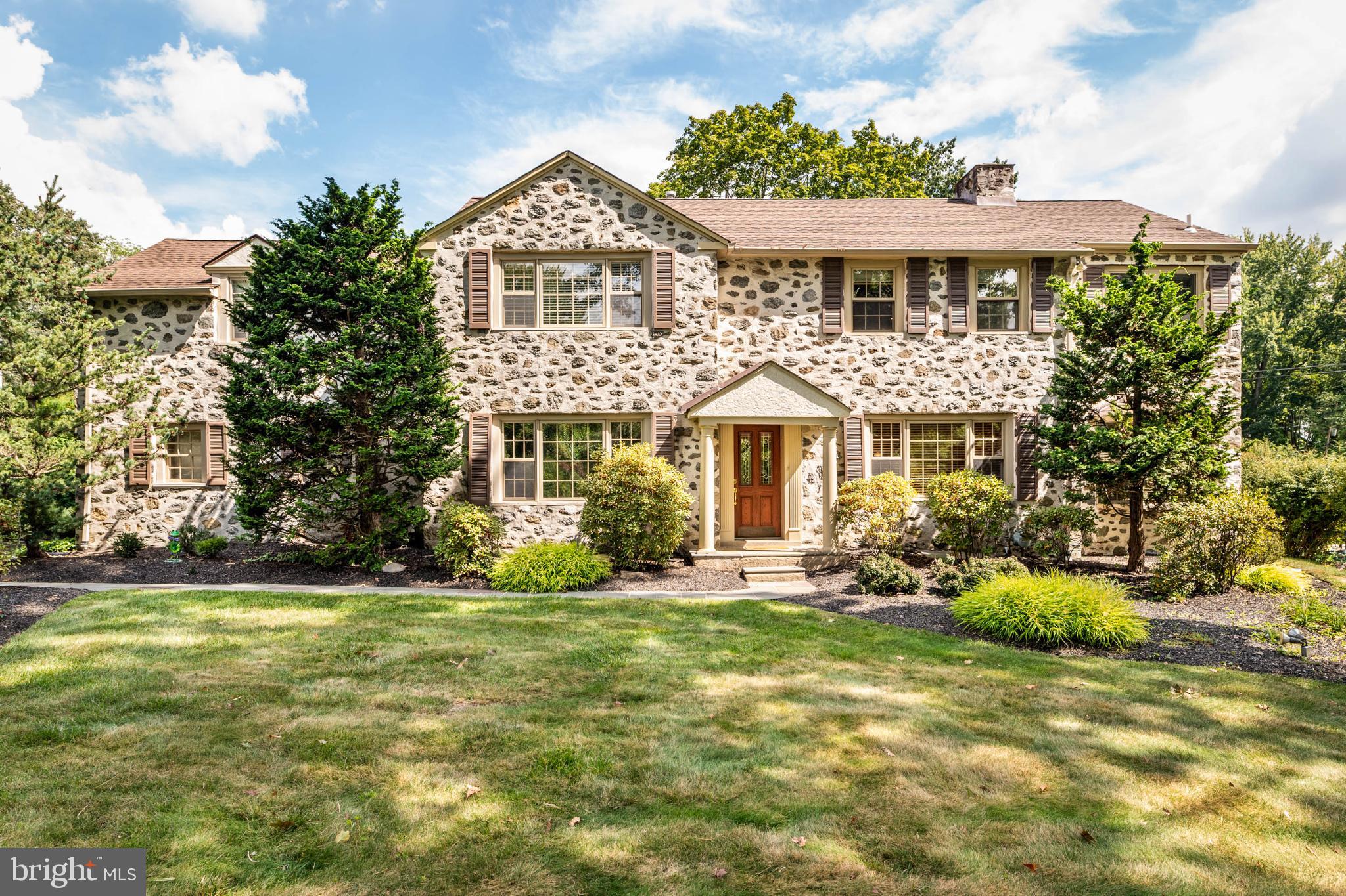 Welcome to your dream home in the heart of Penn Valley, where timeless Main Line charm meets modern, turnkey living. Set on a beautifully manicured, flat backyard oasis, this meticulously maintained 4-bedroom, 3.5-bath colonial invites with stunning curb appeal, anchored by lush professional landscaping and an iconic Japanese maple. Step inside the elegant fieldstone-front entryway and discover sun-drenched spaces with original oak hardwoods, deep-silled windows, and a seamless floor plan designed for effortless entertaining and comfortable everyday living. The versatile living room features a classic, decorative fireplace and custom built-ins, flowing directly into a spacious, beamed family room with skylights and a cozy gas fireplace. French doors throughout the main level create an inviting indoor-outdoor connection, opening to a lovely brick patio and a rare, level backyard, ideal for play, parties, and outdoor upgrades. At the heart of the home, the stylish modern kitchen (boasting cherry cabinetry, granite counters, and GE Profile appliances) connects with a sunny breakfast room and abundant storage. Host memorable dinners in the gracious formal dining room, or work from home in the light-filled office with easy outdoor access. Upstairs offers a generous landing with convenient laundry, and a primary suite with two walk-in closets and a spa-inspired bathroom featuring soaring ceilings, a Palladian window, double vanities, and a luxurious walk-in steam shower. Three additional bedrooms, including a guest or au pair suite with dedicated stairs and an en suite bath, offer flexible living options for every need. A finished lower-level provides bonus flex space, perfect for playroom, gym, or media lounge, plus plenty of storage. Enjoy true convenience with an attached 2-car garage, extra parking, and a mudroom for all-weather access. Served by top-rated Lower Merion schools within walking distance, this move-in ready home combines  prestige with the convenience of easy access to shopping, dining, and a Center City commute. Unlock the Main Line's premier lifestyle.  Schedule your showing today before this rare opportunity disappears.