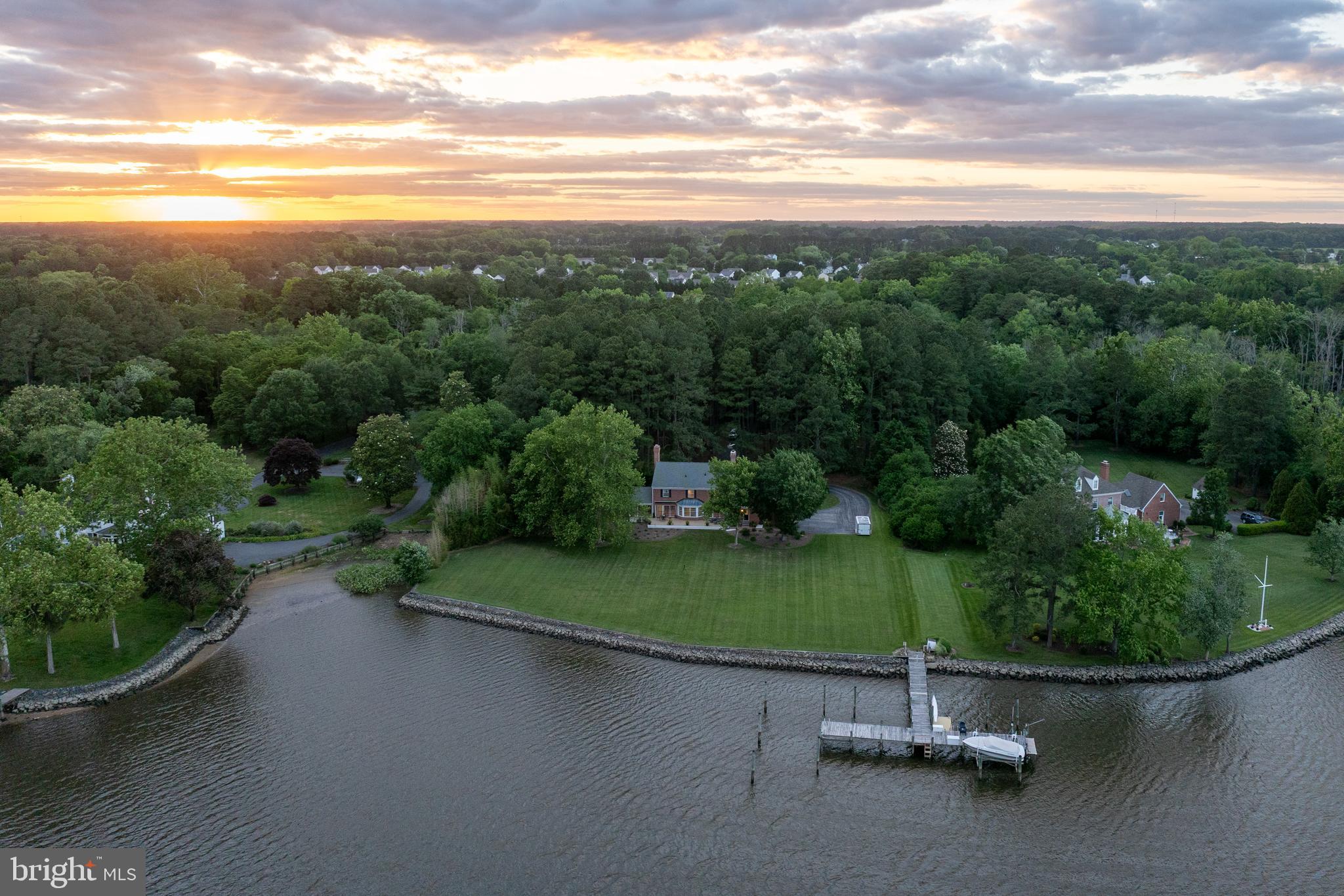 Welcome to a truly exceptional waterfront retreat set on 2.78 scenic acres along the Wicomico River. This beautifully crafted 3,015 sq. ft. brick residence, custom built by Robert Messick, blends timeless design with thoughtful modern updates—all in an unparalleled setting.
The property showcases sweeping, unobstructed panoramic water views, complemented by a clean, rip-rapped shoreline with no marsh. A rare, expansive stretch of flat lawn extends to the river’s edge, adorned with mature shade trees—creating the perfect backdrop for outdoor living. Whether you envision a private pool, an entertainer’s patio, or simply a peaceful riverside escape, this setting offers endless possibilities.
A shared pier provides convenient water access, with designated space for your boat, while a structured pine forest at the entrance creates a picturesque, shaded approach. Tucked away on exclusive Cotton Patch Island, this secluded home is accessed by a private road serving only a handful of residences. Despite its serene setting, the property is just 15 minutes from PRMC, Salisbury University, and the vibrant downtown area—offering the ideal balance of privacy and convenience.
Inside, the home has been extensively renovated by its current owners. Highlights include a beautifully updated kitchen, fully remodeled bathrooms, new hardwood flooring, enhanced trim and moldings, and a recently added composite deck with shade awnings—perfect for enjoying the breathtaking river views. A significant investment was also made to connect the home to public water and sewer.
The spacious layout features 4 bedrooms and 3.5 baths, including a primary suite with two walk-in closets and a private en-suite bath. Additional spaces include formal living and dining rooms, a first-floor office with built-ins, a charming brick sunroom, a full bath on the main level (ideal for future pool use or post-outdoor cleanup), a half bath, and a dedicated laundry room. Upstairs offers three generously sized guest rooms and a large shared bath. A walk-up attic provides abundant storage and potential for future expansion.
Additional features include a 2-car attached garage, an expansive blacktop driveway with ample parking, brick walkways, irrigation system, Dry-Tek crawl space, and a roof installed approximately 12 years ago by Spicer Brothers.
This property is not part of an HOA (though basic deed restrictions apply), is serviced by city water and sewer, and is located within the Chesapeake Bay Critical Area. Flood insurance is approximately $800/year. Buyers are encouraged to perform due diligence regarding the addition of an in-ground pool. 
Offered AS-IS, with inspections welcome—this is a rare opportunity to own an extraordinary waterfront property with space, privacy, and exceptional potential.
