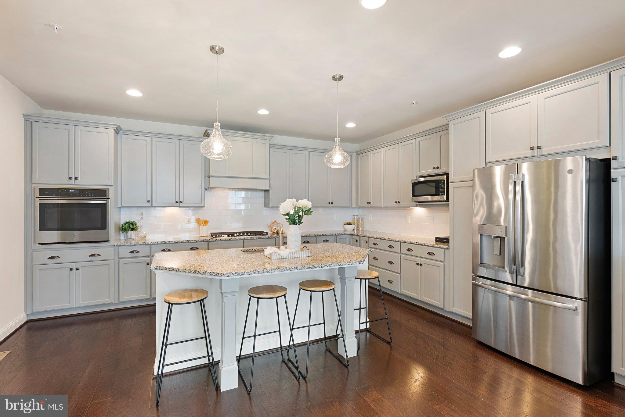 Discover the ease of upscale, low-maintenance living in the highly sought-after 55+ community of Two Rivers. Villas like this are rarely available and highly desirable for their unique appeal. Thoughtfully designed for comfort, convenience, and active adult living, this exceptional and economical end-unit villa offers beautifully finished living space perfect for those ready to enjoy life without the burden of constant upkeep.
This four-bedroom, four-bath villa was built by the highly respected Classic Group Builders and is known as one of the most sought after models, the “Vivian Model.” It features over $75K of premium upgrades, abundant natural light, and luxurious finishes throughout. The main level is designed for easy single-level living and includes a spacious primary suite with a spa-inspired bath, dual vanities, and an oversized walk-in closet. The open-concept layout creates a warm and inviting atmosphere with 9-foot ceilings, elegant living, dining spaces, and a dedicated home office for added flexibility. Additional conveniences include an interior entrance to the kitchen from the attached garage, laundry room with an energy-efficient washer, dryer and utility sink. 
The gourmet kitchen is sure to delight anyone who enjoys cooking or entertaining. Granite countertops, a large center island, stainless steel appliances, hardwood floors, and custom cabinetry provide both beauty and functionality for everyday living and special gatherings. Unwind on the paver patio with a comfortable sitting area, perfect for cookouts, casual gatherings, and getting to know the community’s welcoming neighbors.
Upstairs, guests will appreciate their own private retreat featuring a spacious bedroom, en suite bath, and a versatile loft area perfect for hobbies, reading, or additional entertaining space. The finished lower level offers a large recreation room ideal for movie nights, visiting grandchildren, hosting game-day gatherings, or accommodating a college student, along with abundant storage space. You’ll never have to worry about where to store your holiday decorations again.
Life at Two Rivers is about more than just a beautiful home—it’s a lifestyle. Residents enjoy resort-style amenities including indoor and outdoor pools, a state-of-the-art fitness center, pickleball and tennis courts, walking and biking trails, a yoga studio, and a vibrant social calendar. Best of all, lawn care and snow removal are included through the HOA, allowing you more time to travel, relax, and enjoy the things that matter most.