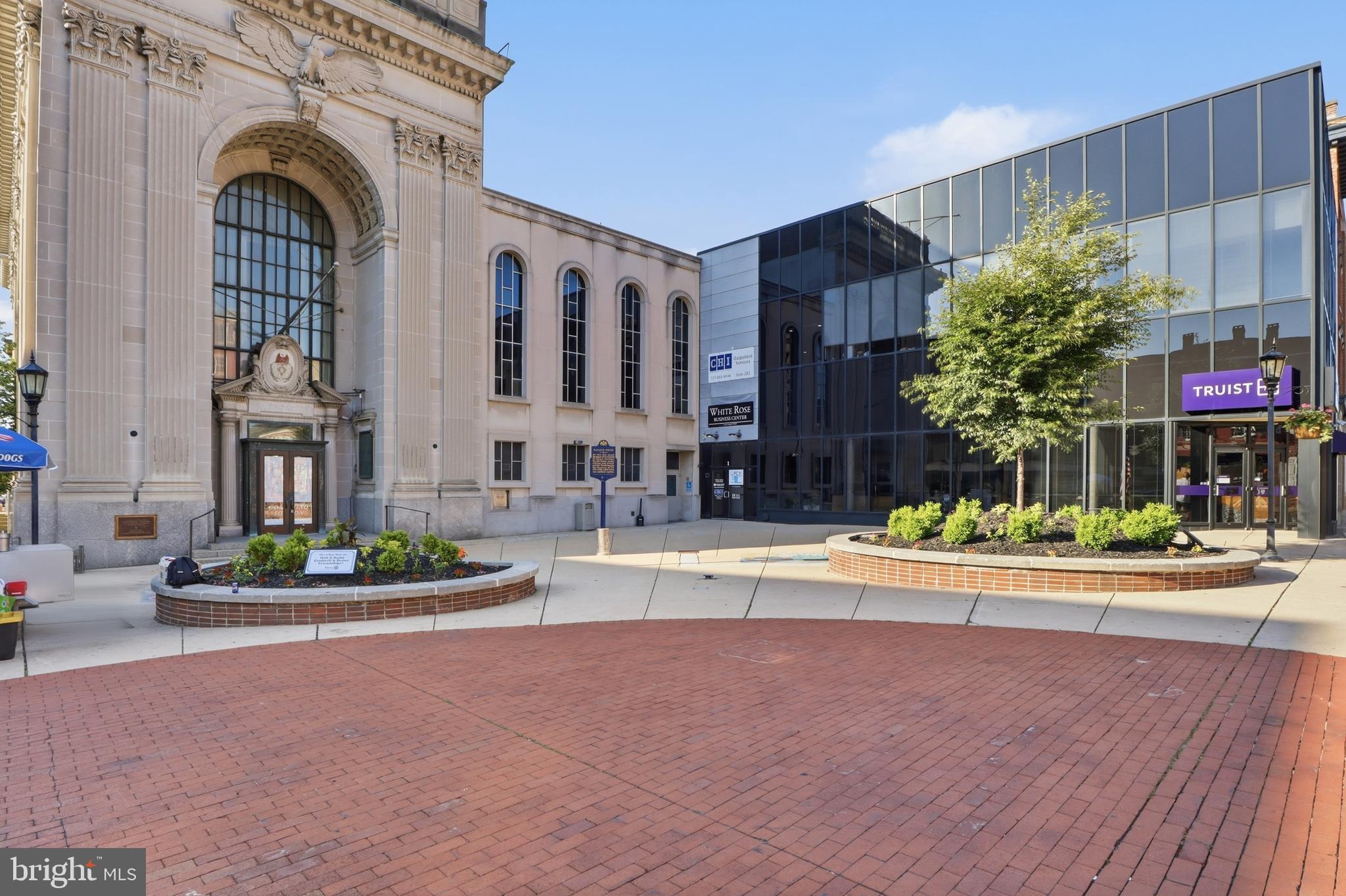 Position your business in the heart of downtown York , Continental Square, with this versatile second-floor office condo at 1 E. Market St Unit #204. This space offers over 1,200 sq. ft. of recently painted space with newer carpet, this property features a flexible layout with four private office spaces plus a kitchenette/lounge area complete with sink and refrigerator. Central AC provides year-round comfort, and all utilities are included except for cable, making this an ideal setup for a wide variety of professional, creative, or service-based businesses.
Previously utilized as a real estate office, embroidery business, and 3D printing company, the space easily adapts to attorneys, therapists, accountants, mortgage or insurance professionals, marketing agencies, wellness providers, startups, coworking concepts, and more. The multi-room configuration provides excellent flexibility for private offices, conference areas, client meeting rooms, or collaborative workspace.
Secure keyed restrooms are conveniently located directly outside the unit on the same floor, providing easy access for staff and clients while maximizing the interior office layout. In addition to the already awesome space there is a bonus ballroom size conference area that can be reserved for events, workshops or large presentation purposes.
Located in a prime downtown setting surrounded by restaurants, coffee shops, banking, government offices, and local businesses, this location offers convenience, visibility, and walkability for both clients and employees. A rare opportunity for an owner-occupant or investor seeking professional office space in one of York’s most recognizable locations. There is a video available upon request and on agents social media.