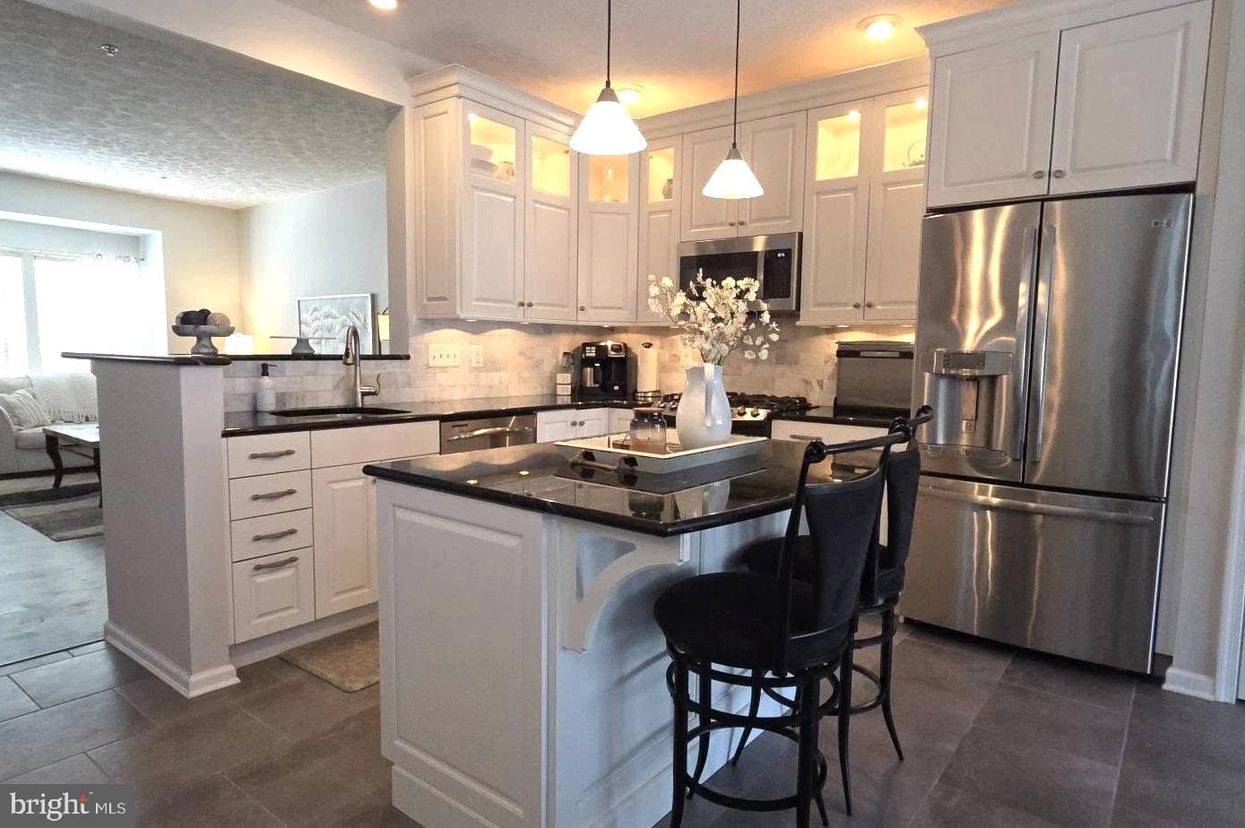 Actual living space with its 3-story bumpout is estimated at 2,360 sq. ft.  Stunning, and perfectly maintained best describes this beautiful, 3-story garage-front townhouse, conveniently located in Perry Hall.  The ground level foyer with a powder room welcomes you from the garage and main entry, that opens to an expansive family room & laundry room, all of which walks out directly to your covered pavers patio.  On the main living level enjoy your stunning, modern, eat-in kitchen with elegant white cabinetry & gleaming black granite countertops, a breakfast bar island and “GE Profile” stainless steel appliances throughout.  The table area, filled with sunlight leads to your spacious, maintenance-free deck overlooking a wooded vista with colorful sunsets.  Just steps away is your bump-out sunroom which provides a warm & comfortable setting for reading and relaxation; or it can be used as an in-home office or toddler’s playroom.  The living room with abundant natural light is the perfect place to gather with family and friends.  In the upper level enjoy a spacious primary suite with a walk-in closet, and a luxurious garden bath with a jetted “Jacuzzi” tub, separate easy step-in tiled shower & dual vanity.  Both secondary bedrooms are carpeted, and the hall bath is only a few steps away. The garage provides remote door entry and additional space for storage.  The driveway is your 2nd option for off-street parking, and guest parking is available across the street.  Some of the updates include the elegant modern kitchen, the roof, garage door, HVAC, new driveway, updated flooring, freshly painted, and so much more, Its most desirable feature is a location that’s near popular restaurants, shopping, & professional services, many of which are walking distance.  This is definitely a “Must See Home” that will surely please the most discriminating buyer.
