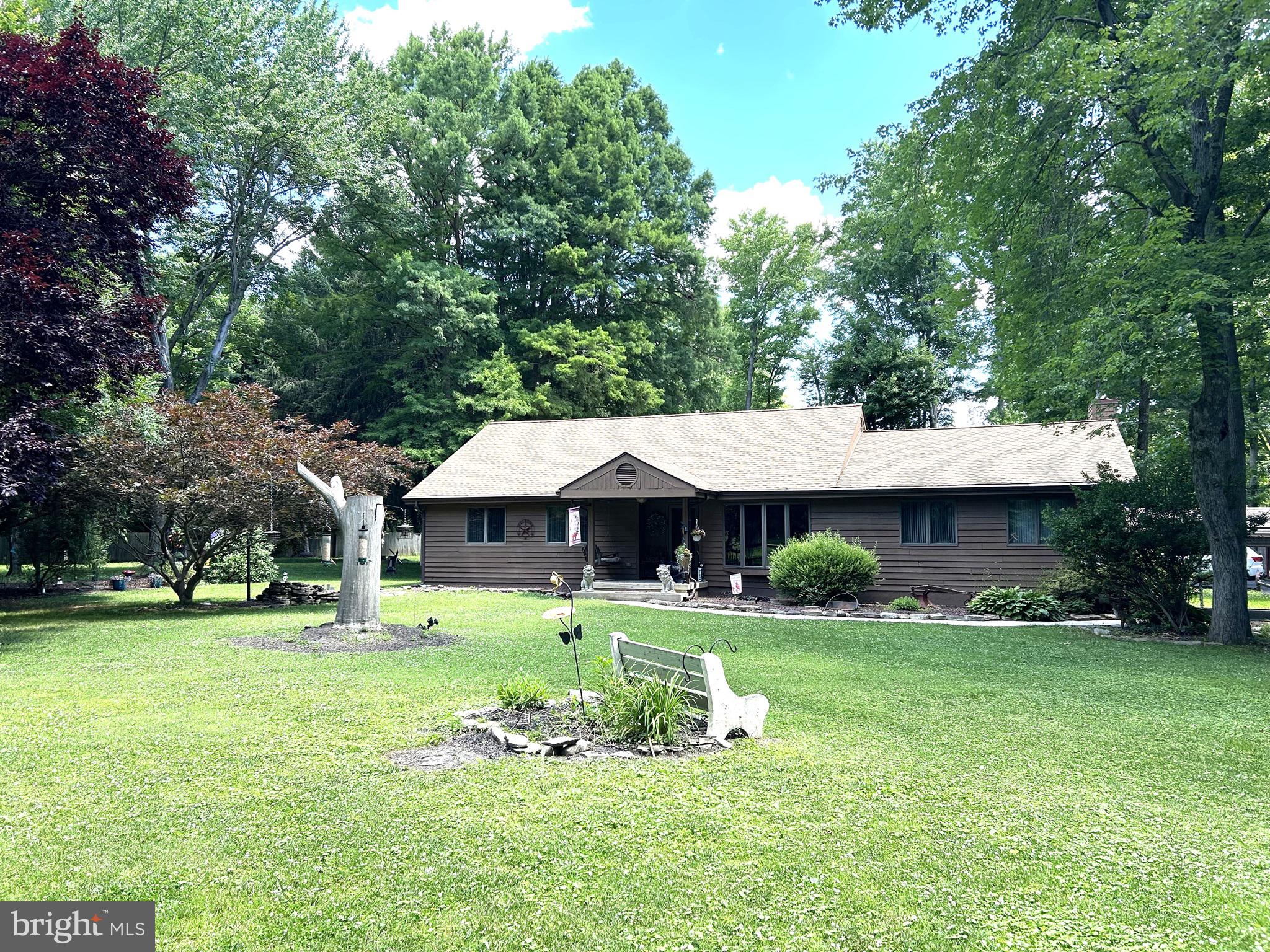 This beautiful 3 bedroom 2 1/2 bath home is quietly hidden back in the woods! This private acre has no deed restrictions! Inside has had plenty of updating! The entire kitchen has been redone! Beautiful solid maple cabinets with copper fixtures, granite countertops, large breakfast bar with stools, instant hot water and French Doors opening onto the enclosed porch. All the bathrooms have been updated and the hall bath has a jacuzzi tub! The family room has an Armstrong wood ceiling with skylights and a wood burning fireplace. New roof in 2024. Great must haves outside include 4 sheds with plenty of storage and a large Amish built cabana with hot tub! This home is on septic but the hook up to NCC sewer is approved and deposit paid. This home has so much to offer! It's one of a kind!