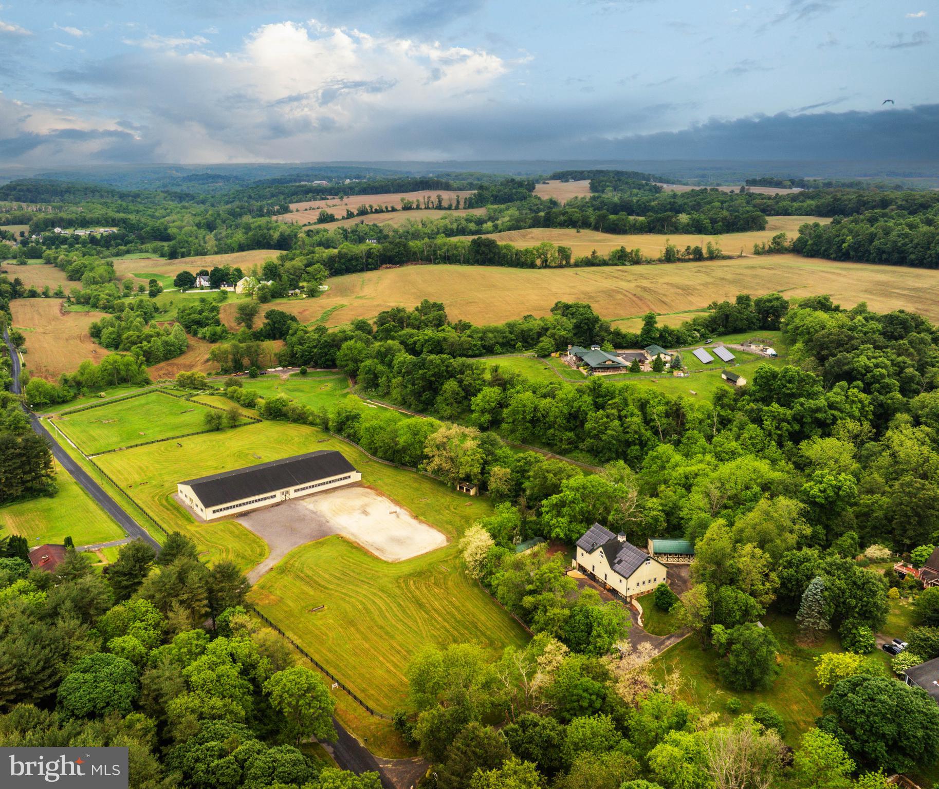 Live authentically. Cedar Crest Farm. Discover a sanctuary where authenticity meets tranquility. Embrace the road less traveled and look forward to meandering through serene country lanes, enveloped by towering trees, leading you to your haven. You have arrived at your equestrian estate. Channeling an enduring Jackson Hole Mountain aesthetic, perched on 19.67 enchanting acres with panoramic big sky views...you won't want to leave. 
Be greeted by a soothing neutral palette and exquisite millwork that showcases superior craftsmanship throughout. Expanses of glass and open spaces frame the beauty surrounding you. Step outside to a 140-foot wraparound covered loggia that terraces to an elaborate 80-foot-long incredible deck, perfect for taking in breathtaking sunsets and sunrises. Enjoy leisurely evenings under the stars on your stunning terrace. The tranquil fountain sculpture, "Coming Together", by Aristides Demetrius, is as remarkable as it is soothing. Let scintillating conversation flow freely by the cozy fireplace and inviting fire pit—ideal for gatherings and quiet reflection alike.
Behold the party barn of all party barns. Three stories of jaw-dropping exposed beams, soaring ceilings and a plethora of possibilities. Complete with its own kitchen, bath and dedicated bedroom space.
For the riding enthusiast, there's an impressive 200x90, 18,000 square foot indoor riding arena where the lights come on instantly. There are mirrors covering the back wall and the walls are canted for safety. No detail is overlooked. The footing is a comfortable mix for horses including bits of tire. Ride effortlessly from the indoor to your outdoor riding arena, complete with jumps and jump storage. There is also a full cross-country course on the property. This includes coops, bank jumps, tables, corners and everything a rider desires. Eight stalls in the bottom barn, one of them currently used as the wash stall equipped with hot and cold water and heat lamps. The upper barn offers a multitude of possibilities due to its spacious and versatile nature...it currently has two stalls. Ample garage space at the house and down at the barn could make an easy conversion to more stalls if needed. The hay shed holds 500+ bales of hay. Ideal for anyone looking to enjoy and utilize a well-equipped equestrian facility, whether for personal use and beyond. Additional features include run-ins and an accessible stream through the bottom fields with a charming bridge. Indulge in luxury with a lap pool and hot tub, providing year-round relaxation and wellness. The lush greenery encircling the property enhances the sense of seclusion and peace. This property is not just a farm, but a lifestyle—a place where every day feels like a retreat. Cultivate your existence. The art of uniting human and home.