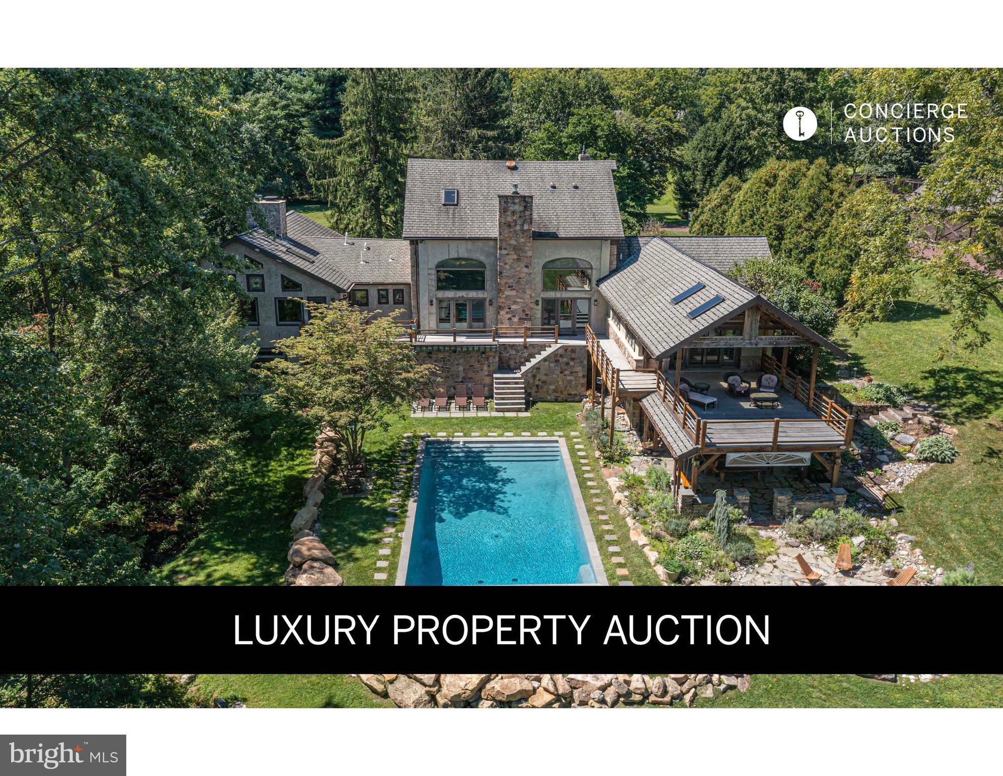 Down a winding gated drive where mature trees frame the approach to Shelly Mill, a breathtaking Arts & Crafts masterpiece born from an 1771 gristmill where the Ely family revolutionized grain processing. This extraordinary sanctuary seamlessly blends centuries of history with modern luxury across nearly 9.5 lush acres. Step inside to discover the completely preserved 18-foot diameter millhouse waterwheel integrated into the main floor, surrounded by thousands of turn-of-the-century Boston Grueby tiles, reclaimed leaded stained glass windows, and a dramatic 35-foot river stone fireplace. Original grand mill doors and interlocking exposed beams tell stories of industrial heritage while an elevator and gourmet kitchen provide contemporary comfort. Outside, entertain around the sparkling saltwater pool and sprawling bluestone terraces, or explore kitchen gardens and endless green space. This livable showpiece offers flexible multigenerational living just minutes from Doylestown, Peddler's Village, and New Hope's vibrant culture.