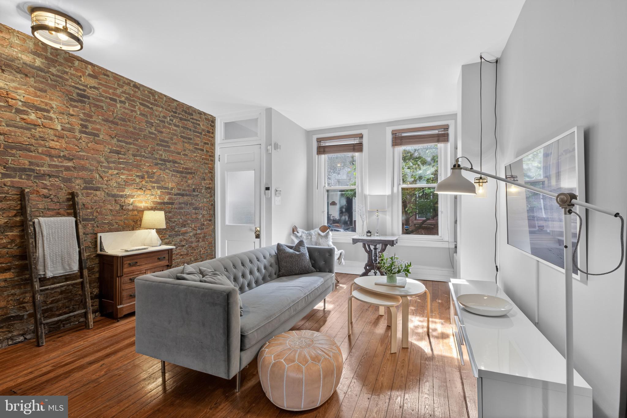 **Back on Market: Buyer got cold feet.** Tucked away on one of Fairmount's quieter, tree-lined blocks, this classic brick rowhome has all the details buyers hope to find—original pine floors, exposed brick, high ceilings, oversized windows, and a private rear patio—but what really sets it apart are the improvements you don't immediately see.
Since the current owner purchased the home, they've invested in the kinds of upgrades that are easy to overlook but expensive to tackle: the sewer line has been fully replaced, the electrical system has been updated and knob-and-tube wiring removed, masonry repairs have been completed, basement window lintels repaired, parging restored, the roof recoated and resealed, and a new gutter installed. Fresh paint, updated fixtures, and additional cosmetic improvements make the home feel move-in ready while preserving its original character.

Inside, the first floor offers a bright, open living and dining space anchored by exposed brick and flooded with natural light from oversized front windows. The kitchen provides generous cabinet storage and opens directly to the rear patio, creating an easy extension of the living space during warmer months.
Upstairs are three bedrooms and an updated bathroom. The primary bedroom easily accommodates a king-sized bed and features two large east-facing windows that fill the room with morning light.
The basement deserves special mention. Unlike many city rowhomes, the ceiling height here creates genuine flexibility. Whether you need substantial storage, a workshop, or envision a future home gym, the space feels usable from day one.

Located within the Bache-Martin catchment and just a short walk from Fairmount favorites like Musette,  A Mano, Brown Street Coffee, The Lucky Goat, the Art Museum, Kelly Drive, and the Schuylkill River Trail. This is the kind of home that offers both neighborhood charm and practical peace of mind.