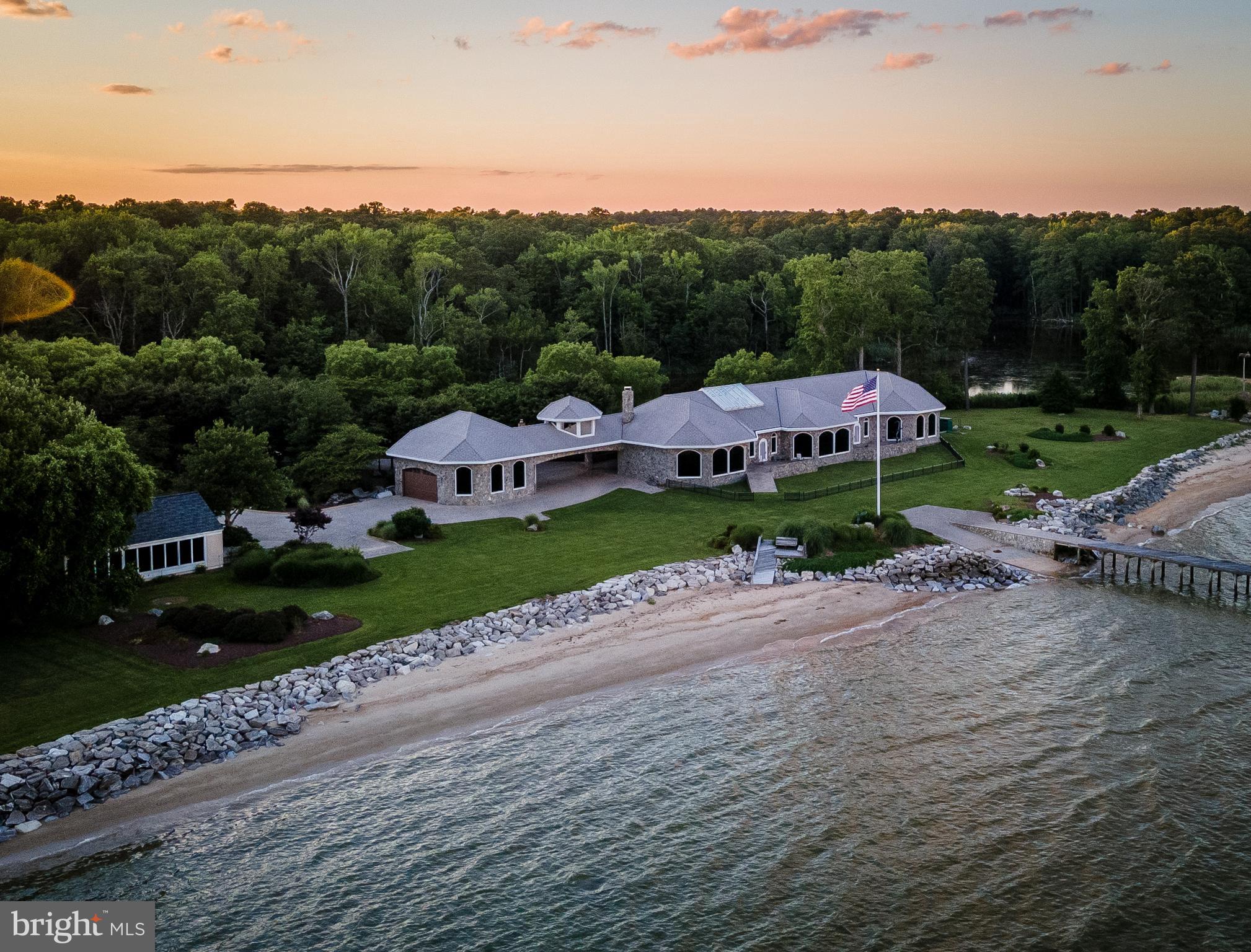 Mediterranean style home with a Caribbean flare!! Property consists of 3 separate parcels.  Main house, full guest house on waterfront lot & 3rd parcel is  pond lot.  Both houses have private beaches & beautiful panoramic views of the Chesapeake Bay.  (Tax info only reflects main house.)    Custom design, custom features, custom materials. No expense spared.   Stone exterior w/ 2x 6 construction. Pella windows and custom picture windows w/ commercial  grade tinted glass.  Slate roof.  Brazilian cherry wood floors thru out w/ marble & tile  in bathrooms. Stone fireplace.  Gourmet Kitchen has high end appliances to include Wolfe gas range  & additional  cooktop.  Two dining areas, one overlooks the pond and the other overlooks the Bay with custom made table and chairs for 20!! High ceilings thru out with custom ceilings & lights.  Indoor atrium w/ waterfall.  Outdoor kitchen has 3 electric roll up doors,  stainless appliances,  granite counter and seating for 10+.  One well , two septic systems. 
560 feet of private beach with plenty of sea glass.  Gorgeous Sunrise views.   Island gazebo.  Pier with sundeck & 2nd gazebo. Sandy bottom makes a great swimming area.   Boat ramp. Rip rap.  Indoor & outdoor sprinklers.  Full house generator.  Brick paver circle drive and parking area.  Portico/ Breezeway to  42 x  36  garage. 2 patios on Bay side.  Multi zone  HVAC system.  Beautifully landscaped, resort setting......