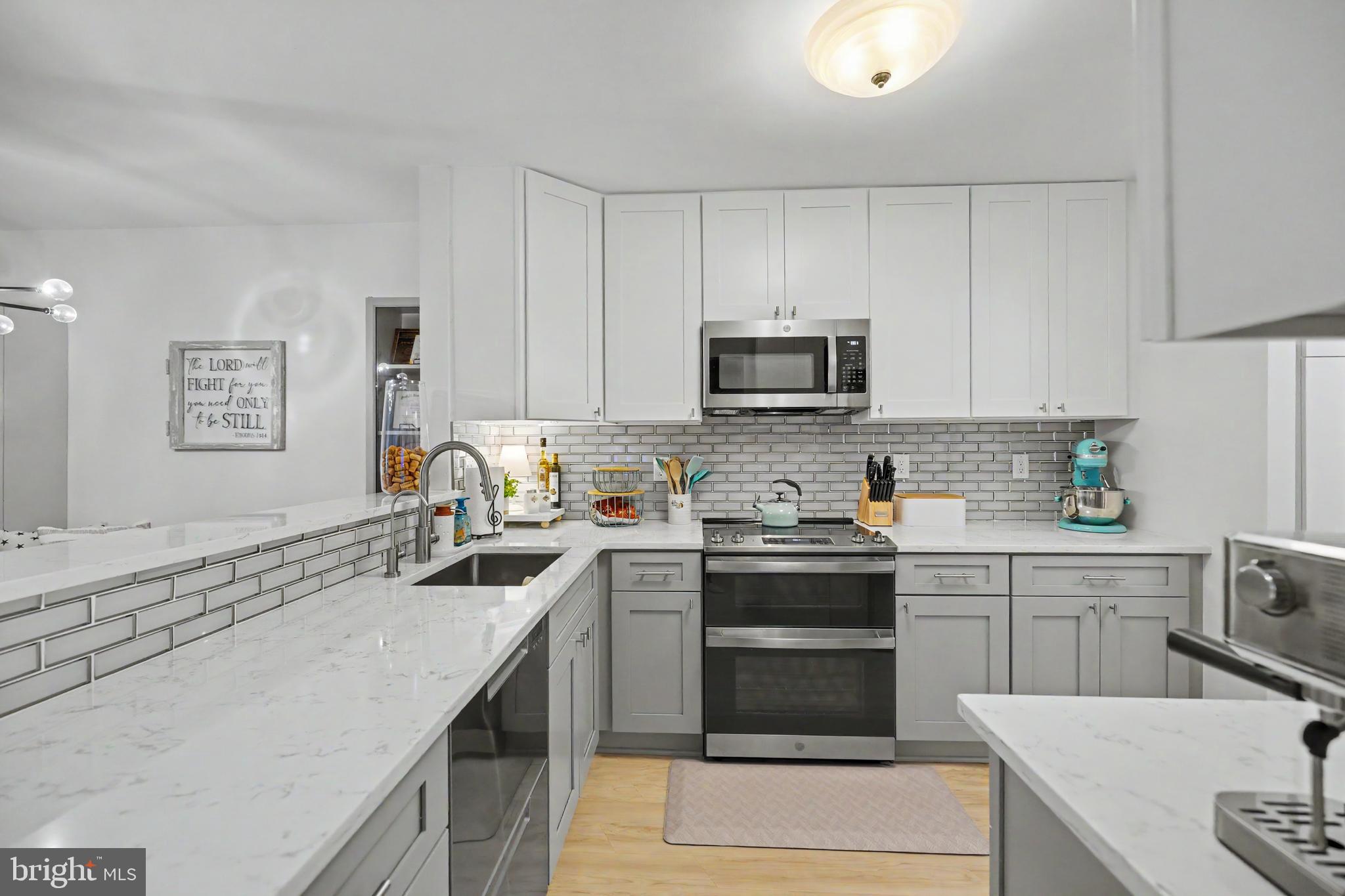 Rarely does a condo offer this level of luxury, storage, and thoughtful design. This beautifully renovated main-level home has been extensively updated with high-end finishes throughout, creating the feel of a custom residence at an exceptional value. The stunning 2025 kitchen renovation is truly the heart of the home, featuring ceiling-height shaker cabinetry, quartz countertops, designer tile backsplash, filtered water tap, upgraded faucet, garbage disposal, and a rare two-drawer dishwasher. The abundant cabinetry and expansive counter space provide both beauty and functionality for everyday living and entertaining.
Storage is extraordinary throughout the home, highlighted by a custom dual-pantry system featuring floor-to-ceiling cabinetry with pull-out drawers that offer an incredible amount of organized storage rarely found in condominium living. The laundry room has also been enhanced with custom cabinetry and shelving for maximum efficiency.  The spacious living room showcases a striking floor-to-ceiling tiled accent wall with a designer electric fireplace featuring 12 ember-bed color options and 13 flame color combinations, allowing you to customize the ambiance to fit any mood or occasion. This dramatic focal point creates a warm, inviting atmosphere and elevates the space with a modern luxury feel. 
Additional upgrades include luxury vinyl plank flooring throughout the main living areas, new carpet, upgraded baseboards, removal of all popcorn ceilings, custom built-ins in the primary closet, and a beautiful dining area featuring a new designer light fixture,  bench seating, and matching cabinetry for additional storage and style. Outdoor living is equally inviting with both front and rear patios offering plenty of room for flower pots, container gardens, relaxing, or entertaining. Enjoy easy access to the WO&D Trail for walking, biking, and outdoor recreation. Meticulously maintained and completely move-in ready, this exceptional home offers designer finishes, abundant custom storage, and extensive upgrades throughout. Experience luxury living with the convenience of main-level living—all at a condo price.