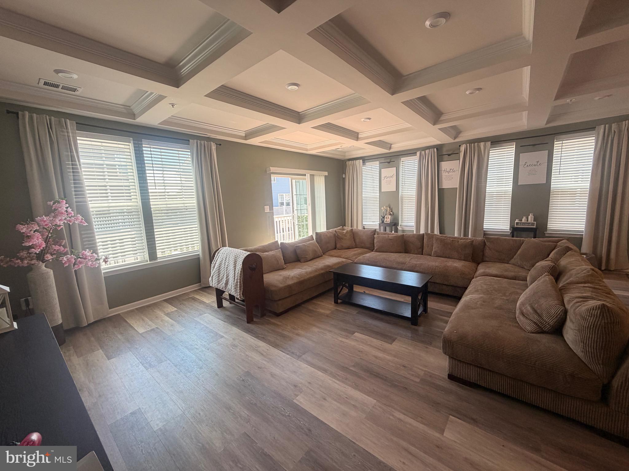 ***OPEN HOUSE POSTPONED TO Saturday 06/27/2026 and Sunday 06/28/2026**********

Welcome to Glenn Dale Commons, where this exceptional upper-level end-unit condo offers over 2,700 square feet of thoughtfully designed living space and the feel of a luxury townhome. Expansive windows on three sides fill the home with natural light, creating a bright and inviting atmosphere throughout.

The main level showcases an open-concept design that seamlessly connects the living room, dining area, and gourmet kitchen. Designed with both style and function in mind, the kitchen features stainless steel appliances, abundant cabinetry, and an impressive waterfall island with seating, making it the perfect gathering space for everyday living and entertaining. Just off the kitchen, a versatile den with elegant coffered ceilings opens to a private deck, offering an ideal space to relax or work from home. Luxury vinyl plank flooring extends throughout the main level, complemented by a convenient powder room for guests.

Upstairs, you'll find three generously sized bedrooms, including a spacious primary suite complete with a large walk-in closet and a spa-inspired en suite bath featuring dual vanities and a walk-in shower with built-in seating. The secondary bedrooms are large enough to comfortably accommodate king-size beds, while multiple walk-in closets throughout the home provide exceptional storage. A dedicated laundry area with a front-load washer and dryer adds everyday convenience.

Additional highlights include a rear-entry one-car garage, extra parking, and access to community amenities including walking trails, a dog park, and beautifully maintained common areas.

Ideally located near NASA Goddard, Greenbelt Metro, MARC Train, I-495, Route 50, shopping, dining, and major commuter routes to Washington, DC, Baltimore, and Northern Virginia, this well-maintained, move-in-ready home offers the perfect blend of space, comfort, convenience, and modern design.

Professional Photography Coming Soon.

Brand New Carpets Just Installed June 2026