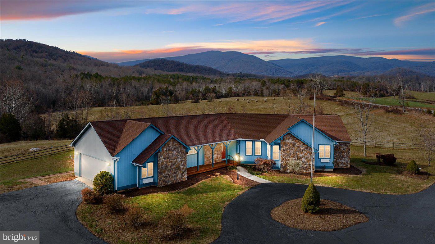 Welcome to your dream home nestled on 2 acres of picturesque landscape with breathtaking panoramic mountain views. This custom-built masterpiece boasts 3 bedrooms and 4 baths, providing the perfect blend of luxury and comfort. The finished basement, complete with a convenient kitchenette, offers versatile living space ideal for entertaining or accommodating guests. Immerse yourself in the warmth of the gas fireplace in the spacious living area, and experience the seamless transition to the outdoors through the expansive deck. With ample storage throughout, including a two-car garage, this residence combines practicality with elegance, making it a haven for those seeking a refined and idyllic mountain retreat.