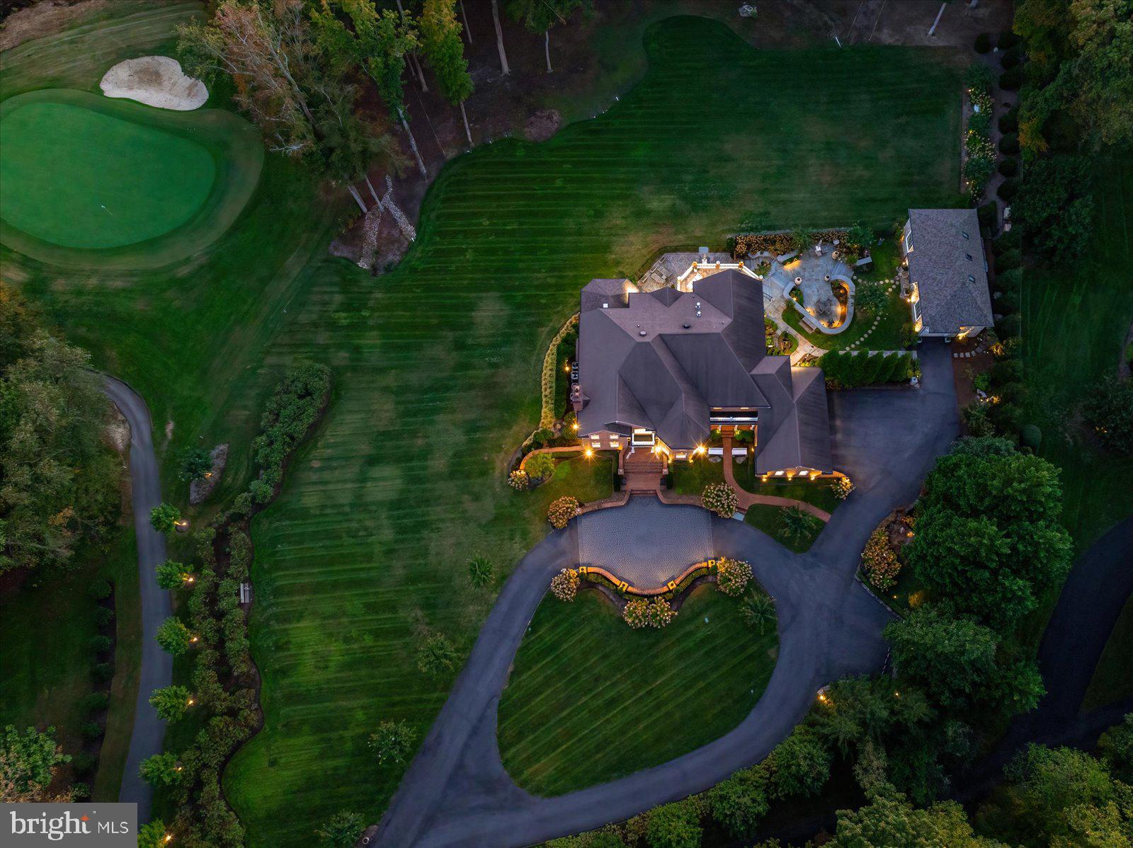 A showpiece estate offering the rare combination of grand scale, modern upgrades, complete privacy, and resort-inspired outdoor living. Set behind a private automated gate on nearly 3 acres, this solid brick estate offers nearly 10,000 sq ft fin. space inc. a detached garage, blending resort-style living, privacy, & modern-meets-classic design. Since 2019, the home has undergone an extensive renovation, inc. plumbing, electrical, UV-protected windows, & a 3-level double door French Style elevator. A newly expanded circular paver driveway & walkways—illuminated by handmade lanterns & low-voltage lighting—wind through curated grounds featuring a "white and pastel" floral palette, a cascading waterfall pond, and a private  750-ft wooded walking trail & "bird-watching sanctuary". A dramatic 2-story, sun-filled foyer welcomes you, highlighted by a Schonbek chandelier, a custom double front door, & a sweeping curved staircase. Distressed maple floors & exceptional artisan-crafted millwork create a sense of cohesion & craftsmanship throughout the home. The main level unfolds with beautifully appointed living spaces designed for both elegant entertaining & everyday comfort. A formal parlor w/ a fireplace offers a refined gathering space, while an artisan-crafted, richly paneled library features a coffered ceiling, a Napoleon Style lighting fixture, & a stately built-in desk. The private dining room is enclosed by a custom metal & glass wall w/double doors, creating an intimate yet dramatic setting for hosting dinners for 12+  guests. The family room—featuring pocket doors & surround sound—is anchored by a striking marble fireplace. It flows seamlessly into the kitchen & opens to private stone balconies, beautifully blending indoor and outdoor living. The chef’s kitchen is both sophisticated and functional, featuring a large central island, premium stainless-steel appliances by Viking and Sub-Zero, a warming drawer, integrated specialty appliances, and 2 climate-controlled walk-in pantries. The sunroom is the most beloved space in the residence. With soaring cathedral ceilings, a dramatic 72-inch linear steel fireplace, & panoramic views of the fairway, it offers an extraordinary retreat. Completing the main level-a spacious mudroom & 2 elegant half-baths, including a distinctive powder room finished w/Belgium blue stone flooring. The French Style 3-floor elevator leads to the upper level featuring 4 spacious bedrooms & three full baths. Enjoy the primary suite, w/a sitting room, double-sided fireplace, oversized closets, & a spa bath w/ marble, mosaic tile, steam shower, &  Schonbek lighting (laundry hookups in-suite). 2 additional bedrooms share a Jack & Jill bath w/stamped marble floors, while the 4th guest suite has a private luxe jacuzzi bath. The walk-out lower level includes a family room w/a fireplace, an executive office w/custom woodwork &  dedicated mini split HVAC, a private guest suite w/ a rainfall shower, & a fitness room w/ a sauna & red-light therapy. It is anchored by a custom mahogany bar w/ black granite flooring, a tap pump, 200+ bottle wine storage, & a kitchenette area. This level features LED-lit steps, Coretec flooring, a large covered stone patio ideal for outdoor gatherings, a spectacular laundry center, specialized utility rooms, and 2023 custom-cabinetry storage. The home offers unparalleled infrastructure: a 2019 well with 3 HP pump, dual Generac generators, four HVAC systems with five zones and mini-splits, instant-hot water, and a certified CertainTeed Presidential roof. A 2024 AV rack seamlessly controls Sonos, Lutron, and battery-backed Ubiquiti Wi-Fi. The 2,000 sq. ft. (est) detached stone building, boasts soaring bays, a cargo lift, EV charging, and natural stone detailing—a collector’s dream for cars, boats, or hobbies. Resort-style amenities:pools, tennis/pickleball, playground, walking paths & picnic area.
