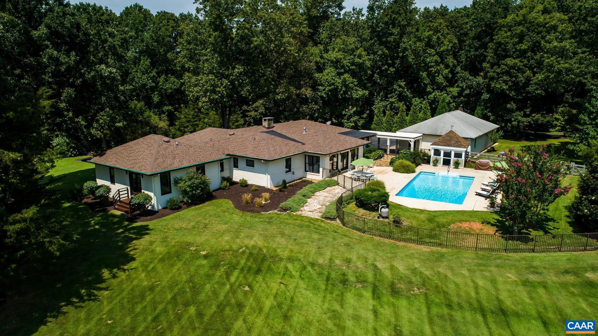 Gorgeous 28+ acre pastoral property off Garth Rd. w/ spectacular views & exquisite contemporary home. Everything about this property was designed for easy-living & to maximize indoor/outdoor enjoyment of the private, estate setting. The all one level "California-contemporary" style floor plan was built around a beautifully landscaped courtyard w/ charming gazebo, blooming hydrangeas & fabulous pool, overlooking sweeping pasture. Acres of uniquely level, open lawn space offer endless options for entertaining & recreation. The open floor plan combines kitchen, living & dining areas to create an ideal gathering space in the center of the home. From the main living area, the home flows beautifully to the bedroom suites & functional wet bar, pantry, office & laundry area w/ quick covered access to the detached 4-car garage. The home's custom-built, primary bedroom wing will delight. Looking for a special country property w/ quick proximity to UVA, downtown & Western Schools? This is it!,Granite Counter,Painted Cabinets,White Cabinets,Wood Cabinets,Fireplace in Living Room