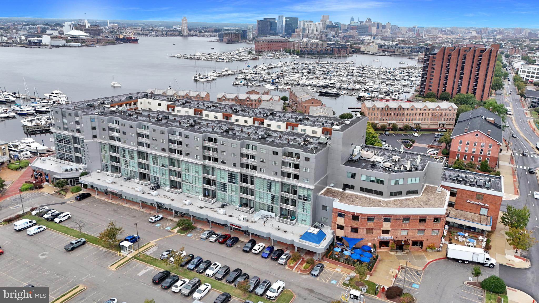 Welcome to resort-style living at Canton’s Waterfront! This contemporary two-bedroom, two-bathroom condo offers a luxurious lifestyle with stunning water views visible from the private balcony and nearly every room. The home features a bright, open floor plan with LVP flooring throughout the main living area and cozy carpeting in the bedrooms. The primary bedroom includes an en-suite bathroom, and both bedrooms boast large walk-in closets for ample storage. Recent upgrades include a smart thermostat, a new dishwasher (2024), and a hot water heater (2020).  Residents enjoy a wealth of amenities, including a front desk concierge, 24-hour security, and a gated community, along with the convenience of Lighthouse Canton wine, liquor, and deli located on the first floor. Fitness enthusiasts will appreciate the  on-site fitness center. Parking is hassle-free with a deeded garage spot and plenty of street parking for guests. The condo offers easy access to I-95, 895, and 83. Plus, it's pet-friendly and within walking distance to Canton and Fells Point's finest local dining, bars, grocery stores, and boutique shops.