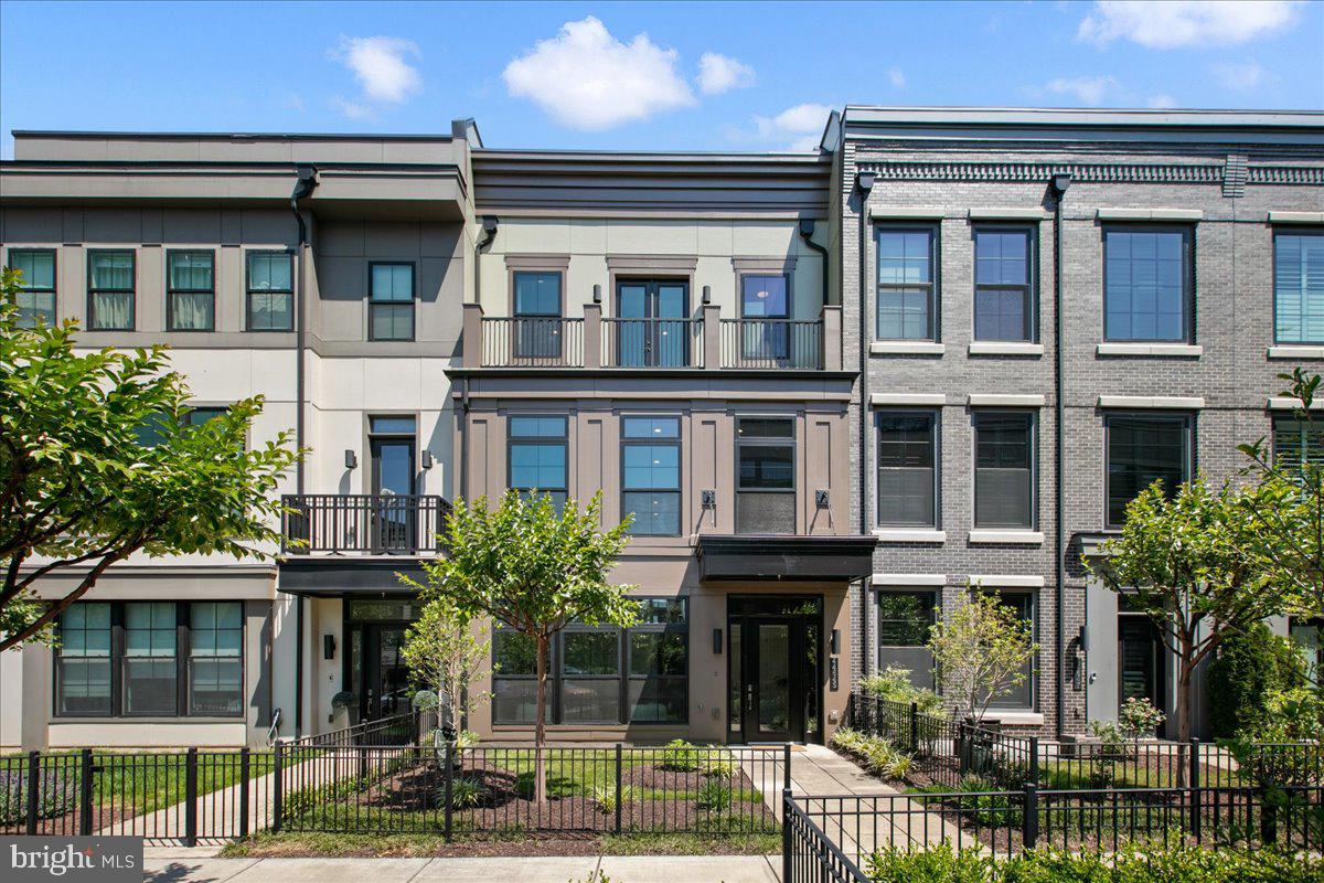 Experience elevated living in this extraordinary 4-level elevator townhome in the heart of highly sought-after One Loudoun. Perfectly positioned on desirable Danvers Terrace with picturesque green space views and breathtaking sunsets, this luxury residence blends sophisticated design, premium finishes, and the convenience of a low-maintenance lifestyle in one of Loudoun County’s most vibrant and walkable communities. One of the most spacious models in the community, the home showcases extensive custom upgrades, exceptional craftsmanship, and elegant modern design throughout.

Designed with both sophistication and functionality in mind, the home features impressive 10-foot ceilings, upgraded stunning 7-inch hardwood flooring throughout every level — including all bedrooms — and elevator access servicing all four floors. The entry level offers incredible flexibility with a welcoming vestibule, spacious family room, private office or optional main-level bedroom, powder room with floating vanity, mudroom with custom storage solutions, and access to the rear-load two-car garage. Thoughtful custom details include built-in floating cabinetry in the office, a Scandi entry bench with integrated drawers, and a convenient pocket door enclosure beneath the stairs.

The main living level is the true centerpiece of the home, designed for luxurious entertaining and everyday comfort. The chef’s kitchen is a showpiece, featuring premium Wolf and SubZero appliances including a Wolf 6-burner cooktop, convection steam oven, convection oven and microwave, and paneled SubZero refrigerator. Oversized quartz waterfall island, upgraded cabinetry with recessed lighting, walk-in pantry, and designer finishes complete the space. Four Bang & Olufsen ceiling speakers elevate the kitchen experience, while the open-concept layout seamlessly connects the kitchen, dining area, additional powder room with floating vanity and Great Room with gas fireplace, floating shelves, and integrated surround sound speakers. Just off the dining area, enjoy a private balcony perfect for morning coffee or evening relaxation.

Retreat to the luxurious primary suite on the third level, where refined finishes create a serene atmosphere. The spa-inspired primary bath features dual sinks in a contemporary floating vanity, soaking tub, and oversized walk-in shower. The custom walk-in closet is truly exceptional with inlaid cabinetry, double-decker felt-lined jewelry drawers, and thoughtfully designed organization. Two additional bedrooms, an elegant full bath, and a well-appointed laundry room with built-in cabinetry, hanging space, and integrated hampers complete this level.

The fourth floor offers even more flexible living space with a loft-style entertaining area, fourth bedroom, and full bath with floating vanity. Custom built-in floating cabinetry with hidden remote drawers, surround sound speakers, and premium Haiku ceiling fans create the ultimate retreat. Step outside to the incredible rooftop terrace designed for year-round enjoyment, complete with a gas firepit, stunning sunset views, and expansive outdoor living space perfect for entertaining under the stars.

Additional luxury enhancements include upgraded lighting throughout, Restoration Hardware chrome mirrors, premium Haiku ceiling fans, a fully integrated Control4 smart home system expandable for lighting, music, locks, and more, plus POE-enabled wireless access points.

Located in the center of One Loudoun, residents enjoy access to premier shopping, dining, entertainment, community events, farmers markets, clubhouse amenities, outdoor pool, tennis courts, trails, parks, and more — all just steps from Trader Joe’s, Barnes & Noble, and Alamo Drafthouse, with easy access to major commuter routes. Minutes to Dulles International Airport and the Washington Commanders practice facility, this exceptional home offers the perfect balance of luxury, convenience, and community living.