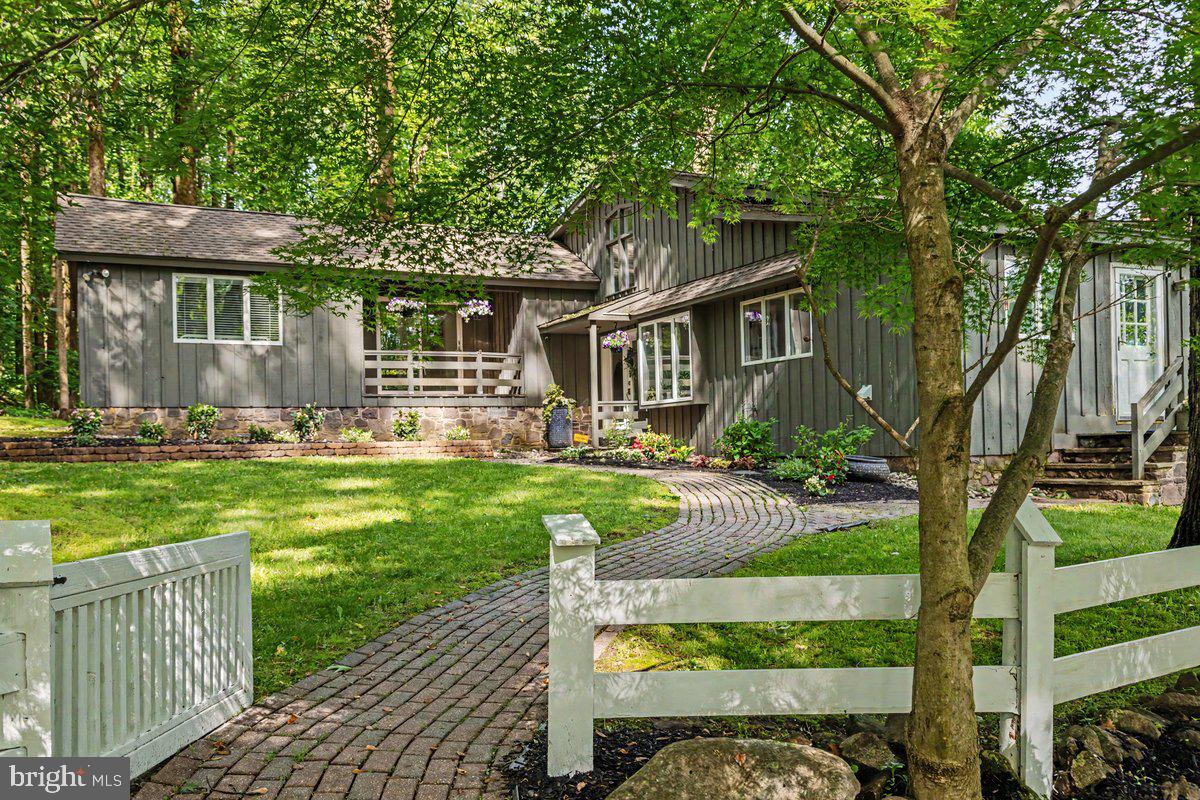 *Showings start Friday 5/29* Overlooking nearly three private acres of mature landscape and treetop scenery within the sought-after New Hope-Solebury School District, this spectacular mid-century modern home offers a rare combination of privacy, elevated views, and quick access to the best of Bucks County living. Set at the end of a quiet cul-de-sac atop Solebury Mountain, the peaceful setting feels removed while remaining just minutes from downtown New Hope, Lambertville, Doylestown, and the area’s beloved river towns, restaurants, galleries, and shops. Inside, warm wood flooring extends across the home, complemented by Italian stone floors at the entry and within the kitchen. The spacious living area features soaring 16’ ceilings and is filled with natural light from expansive floor-to-ceiling windows centered around a stunning oversized stone, wood-burning fireplace. Newly installed oversized Andersen sliding doors lead directly to the rear deck, creating an easy connection to the outdoor living space and elevated surroundings. Pocket doors lead to the dining room, which offers exceptional space for entertaining and access to the deck, while the refreshed kitchen combines style and function with butcher block countertops, double ovens, electric cooktop, peninsula seating, an eat-in area, and abundant pantry storage. A dedicated laundry room with additional storage and coat closet sits just off the kitchen, along with a conveniently located powder room. Upstairs, all bedrooms are generously sized and thoughtfully designed. The primary suite includes private deck access, a walk-in closet, and an ensuite bath with double vanity and shower. A second bedroom features skylights and built-ins, while the third bedroom opens directly to its own balcony. A recently renovated hall bath with tub and shower serves the secondary bedrooms, while multiple oversized closets provide impressive storage capacity. Updated lighting, generous room sizes, and the home’s beautiful architectural lines give the interior an inviting, airy feel. The walk-out lower level offers additional flexibility for entertaining with a full bar and recreation area, a wood-burning fireplace, and a fourth bedroom with full en-suite bathroom and walk-in closet, ideal for an in-law suite, guest quarters, home office, gym, or creative studio. Newly installed dual-zone HVAC, whole-home automatic generator, and beautiful views from every room complete this breathtaking property, offering a compelling blend of style, space, and location in one of the area’s most desirable settings.