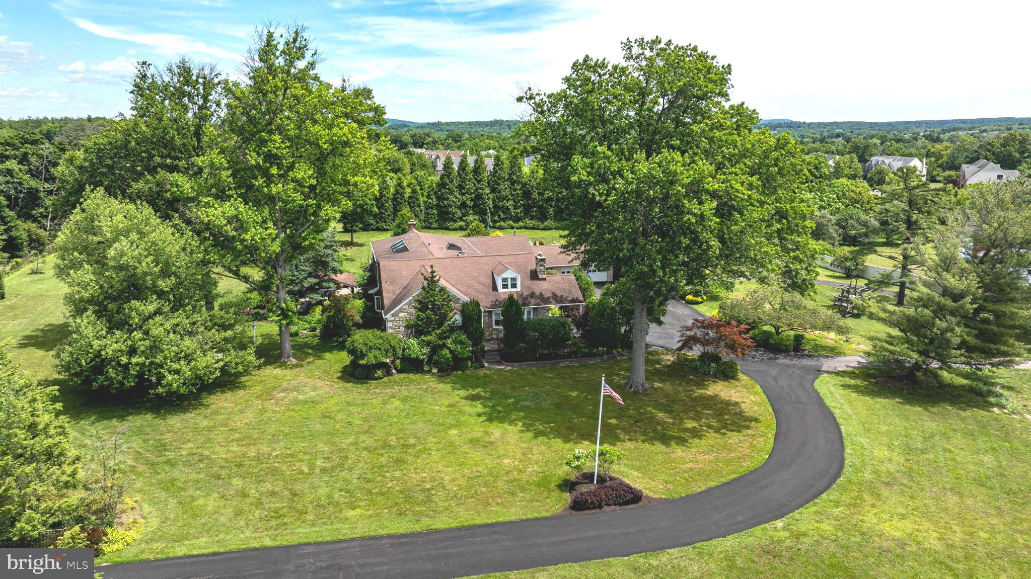 An extraordinary private compound offering an unmatched blend of luxury, elegance, and resort-style living, set on approximately five secluded acres behind a gated entrance, a curved private drive, and a fully fenced perimeter. Surrounded by mature trees and natural beauty, the property creates a remarkable sense of arrival, serenity, and privacy. From the moment you enter, this estate reveals a rare combination of timeless character and thoughtful expansion, where original craftsmanship meets an inspired addition tailored for today's lifestyle. Rich architectural details, hardwood flooring, arched openings, and classic millwork create a warm and sophisticated atmosphere throughout the main residence. Gracious living and dining spaces provide the perfect setting for both everyday comfort and entertaining.At the heart of the home, an expansive custom kitchen serves as the central gathering place. Appointed with white  cabinetry, granite countertops, Mercer tile accents, dual ovens, stainless steel appliances, built-in pantry storage, and a large center island, the space is both functional and inviting. A sun-filled breakfast area framed by a bay window, along with an adjoining sitting area, enhances the open feel. Flowing from the kitchen, the large living room serves as a natural gathering space, anchored by a stone fireplace with mantel. A built-in window seat adds character, comfort, and timeless appeal. Nearby, the formal dining room connects easily to the kitchen and provides an elegant setting for intimate dinners and larger gatherings. A first-floor bedroom or office is complemented by a full bath, offering ideal accommodations for guests, work, or single-level living. A remarkable addition introduces a private guest residence with its own separate entrance. This space features a dramatic two-story vaulted living room with skylights, Palladian windows, and a striking fireplace. Hardwood flooring, a well-appointed kitchen and dining area, and flexible living spaces offer versatility for extended family, guests, or independent living. This space is equally suited for in-law accommodations or extended stays, while also adapting easily for recreation, media, fitness, or play, offering a true second living environment. Upstairs, an open loft overlooking the living area below, adding architectural interest and flexibility. Upstairs in the main home, the property continues to impress with multiple bedrooms, including a serene owner’s retreat with private sitting room, walls of windows, and skylights that fill the space with natural light. The spa-inspired bath includes dual vanities, a soaking tub, glass walk-in shower, and generous closets. A hidden doorway connects the owner’s suite to the guest wing, adding convenience and intrigue. The finished lower level expands the home’s living and entertaining space with durable flooring, wood-accented walls, custom bar and seating area, recreation space, office, storage, powder room, and Bilco walkout access, offering flexibility for work and leisure. Outdoor living is equally impressive. Multiple covered patios, porches, tile details, pergola seating areas, stamped concrete patios, and refined hardscaping create inviting spaces for relaxation and entertaining. Beyond, landscaped gardens, mature trees, open lawns, and a tree swing enhance the peaceful setting. The resort-style pool area serves as the crown jewel of the outdoor experience, featuring a natural stone-inspired finish, brick coping, integrated spa, diving area, and expansive patio and deck spaces designed for entertaining and relaxation. Oversized four-car garage accommodations provide exceptional flexibility for vehicles, collector cars, recreational equipment, hobbies, and storage. A connected garage and poolside structure offer additional storage and future pool house potential with shower and toilet rough-ins already in place. Offered for the first time, this rare estate presents an extraordinary opportunity.