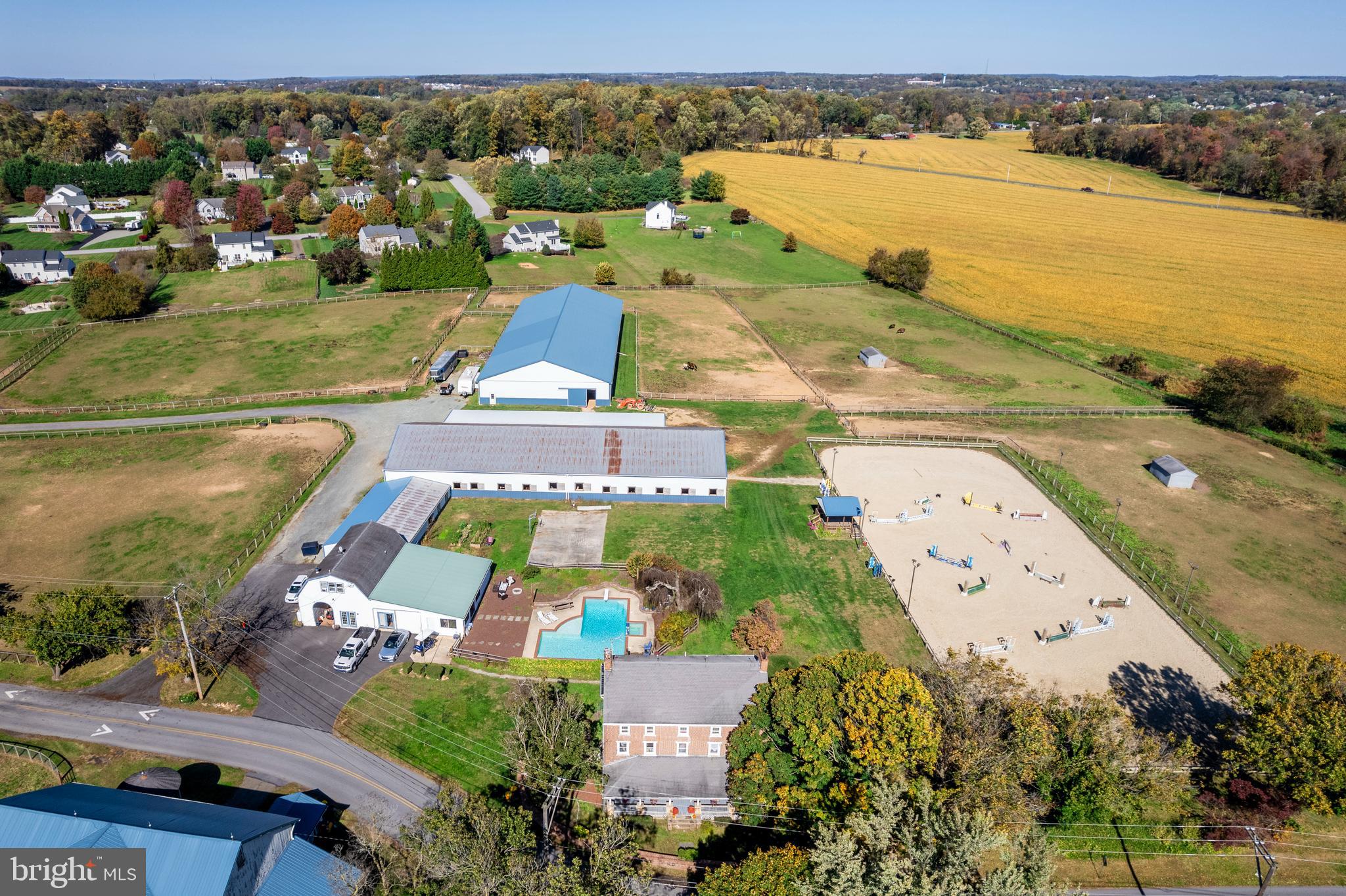 Welcome to Brownstone Farm, a stunning equestrian training center and historic residence set on 12.7± beautifully maintained acres. Originally constructed circa 1772, this solid brick three-story farmhouse blends timeless architecture with modern updates and offers an exceptional opportunity for both gracious country living and professional equestrian pursuits.
The main residence invites you in with a wide 10-foot front porch and a grand entry hall flanked by elegant parlors. The remodeled kitchen (2018) features custom cabinetry with a hand-painted finish, soapstone countertops, a farmhouse sink, subway tile backsplash, stainless steel appliances, and a butcher-block center island with prep sink. A cozy breakfast area with a wall of windows and exposed brick adds warmth and light. Adjacent, the formal dining room boasts built-in china cabinets and a charming corner wood-burning fireplace. Additional living spaces include a great room with arched openings, hardwood floors, and a fireplace plus a formal parlor ideal for entertaining with another fireplace.
The first floor also offers a convenient laundry room with utility sink and a full bath featuring a soapstone vanity. Upstairs, the second floor hosts four generously sized bedrooms and a full bath with clawfoot tub. The third floor provides THREE additional bedrooms with adjoining sitting or sewing rooms / flexible spaces that can serve as offices, craft rooms, or extra storage.
Step outside to your own private retreat. The L-shaped Anthony Sylvan in-ground pool (8’ deep) with adjoining hot tub is surrounded by a 25’ x 15’ patio, an island-themed pool house, fire pit area, and a sports court with basketball hoop. Raised flower beds and mature landscaping complete this peaceful setting.
A two bedroom loft apartment  with downstairs studio offers full amenities and is currently leased & perfect for generating supplemental income or accommodating guests.
Equestrians will appreciate the exceptional facilities:
Main Barn (built 2009): 35 stalls with windows, two tack rooms, three wash stalls (2 heated) with hot/cold water, three tack-up stalls, feed room, hay and straw storage, heated office, heated bathroom, and laundry.
Second Barn: Seven additional stalls, wash stall with hot/cold water, tack and feed rooms, blanket storage & machine storage bays. 
Indoor Riding Arena (built 2010): 80’ x 200’, sand footing, LED lighting, heated viewing room, and spectator seating.
Outdoor Ring (built 2020): 100’ x 240’, excellent base with sand footing, observation deck with electric and ceiling fan.
Fenced paddocks and open pasture complete the setup for a working equestrian facility. Hacking path around the perimeter of the property.
Brownstone Farm is as functional as it is picturesque, offering an established setting for lessons, training, and equestrian shows with proven cash flow potential. Whether you’re seeking a turnkey equestrian operation, a country retreat, or a blend of both—this remarkable property delivers history, character, and opportunity in equal measure.