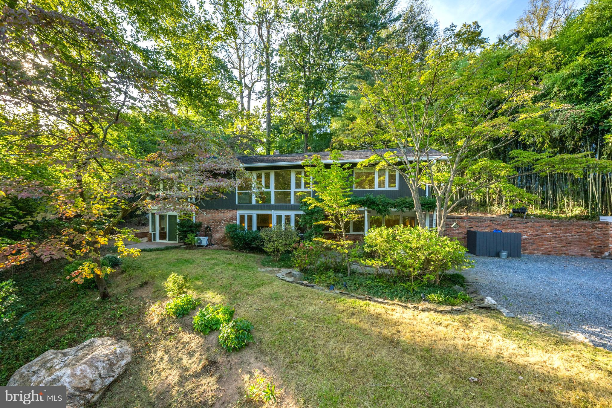 Located in the sought-after Bannockburn community of Bethesda, this elegant mid-century residence offers refined living in a serene, tree-lined setting. Ideally situated near Bannockburn Elementary, the C&O Canal, Glen Echo Park, and downtown Bethesda, with easy access to Clara Barton Pkwy, I-495, and River Road. The open floor plan features a spacious family room with fireplace and glass-enclosed porch, complemented by two bedrooms and a full bath on the entry level. The upper level showcases a light-filled living and dining area, sunroom, and a modern kitchen with island and breakfast nook. The primary suite includes an en-suite bath and double walk-in closets, while a flagstone patio, fire-pit and terraced gardens provide an inviting outdoor retreat.