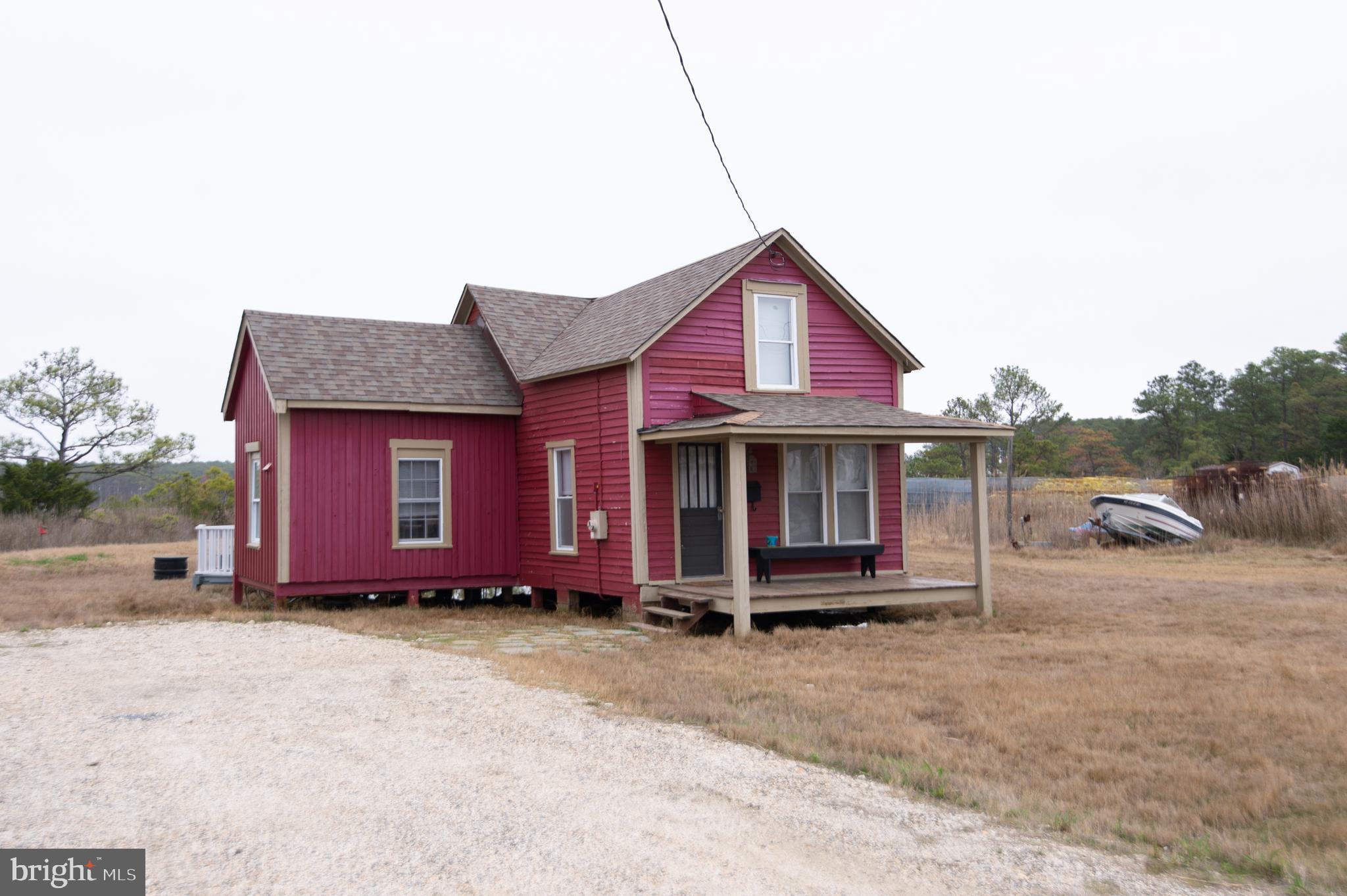 An adorable 2BR/1BA rustic Cottage surrounded by nature is located on Hoopers Island. You are welcomed by a covered front porch perfectly set up for your morning coffee.  Step into the two story living room with exposed wood beams, knotty pine wood floors, and an open view of the second floor loft. The kitchen features a pantry closet, cabinets and open shelving, a stainless steel sink and counter, stainless steel appliances, and a wood breakfast bar with seating and storage below. Behind double doors is a spacious bedroom with tons of sunlight and a beadboard ceiling.  Completing this area is a full bath with a stand alone shower.  The primary bedroom is in the spacious loft with an amazing view of the lower level. From the family room step out onto a spacious wood deck that overlooks the surrounding landscape, and a detached wood shed/coop.  This home is move-in ready with so much to offer. Welcome your island home close to two public boat ramps and water access!