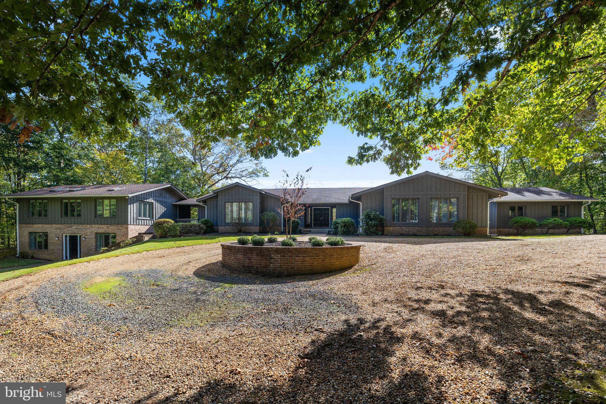 Sitting on almost six wooded acres, this beautiful custom-built home with a three-car garage, has a separate addition for extended family, guests, or home office.  The  main home features a great room with fireplace, a large kitchen/breakfast room, large laundry room, four generously-sized bedrooms, and four beautifully updated bathrooms. The master bedroom has separate his and her bathrooms with walk-in closets. A second spacious bedroom/den has its own bath. A third and fourth bedroom have a new Jack and Jill bath.  The spacious lower level offers unlimited potential, featuring three finished,multi-use rooms, a full bath, and three large storage areas, one of which includes workbenches and electrical outlets, perfect for hobbies or projects.  The separate addition which is accessible from the main house, has its own front entrance, offers living room, kitchen, breakfast area, two bedrooms, one full bath, and its own laundry room, providing a comfortable and private space.  Dogwood Air Park Association has a private runway for owners.