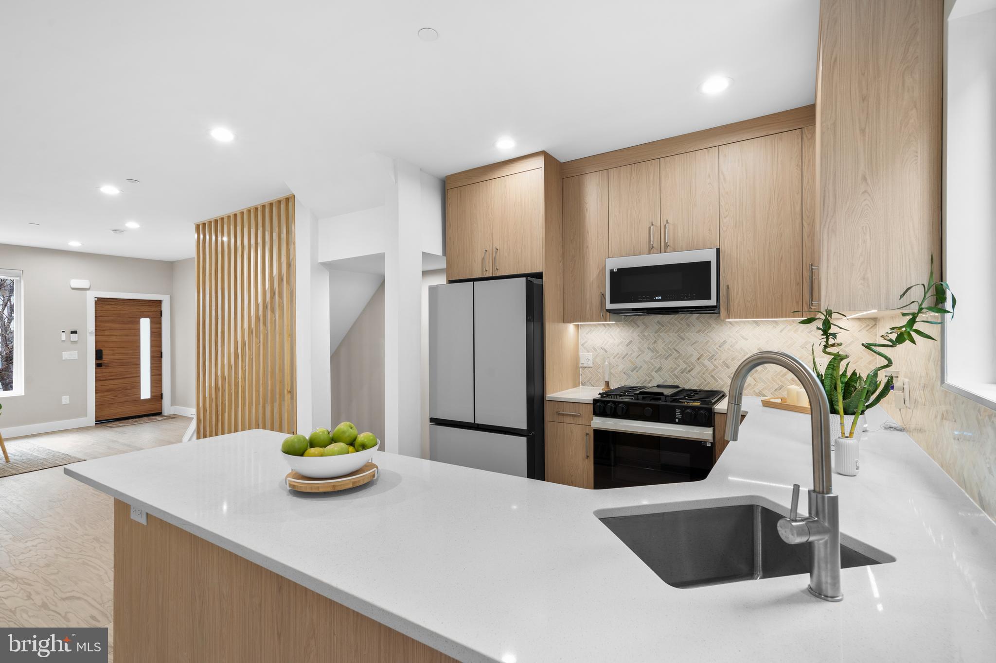 Welcome to 1032 S, Randolph Street, a stunning new construction residence located in the coveted Queens Village. **Estimated $85,000 tax savings over the course of the rarely offered FULL 10 year tax abatement** Thoughtfully designed with a traditional open-concept floor plan and elegant finishes in the heart of Queen Village.  The first floor welcomes you with a spacious, light-filled living and dining area that flows seamlessly into a corner kitchen at the rear of the home. A sturdy feel from the engineered hardwood floors throughout – warm, modern, and durable. The kitchen features sleek cabinetry, premium over hung counter tops, the Samsung Bespoke appliance package, built in wine fridge, and ample prep space - exceptional for those who love to cook and entertain. Leading to a raised deck patio, creating a cozy extension of your living space for morning coffee or summer evenings with friends. This home is equipped with smart features such as – Cameras, locks, thermostats & security at your fingertips. Upstairs, the second floor offers two generous bedrooms separated by a full bathroom and a convenient laundry area. The third floor is the crown jewel of the home - a private primary suite with three distinct areas: a spacious bedroom, a custom walk-in closet with built-in cabinetry, and a spa-like bathroom featuring heated floors, a dual vanity, and a luxurious shower. Finally, ascend to the 360° roof deck where you’ll enjoy sweeping city skyline views - the ultimate spot for hosting gatherings or relaxing under the stars. With smart home features including integrated security cameras, smart locks, and thermostats, you can control your home with the swipe of a finger. Schedule your showing today!