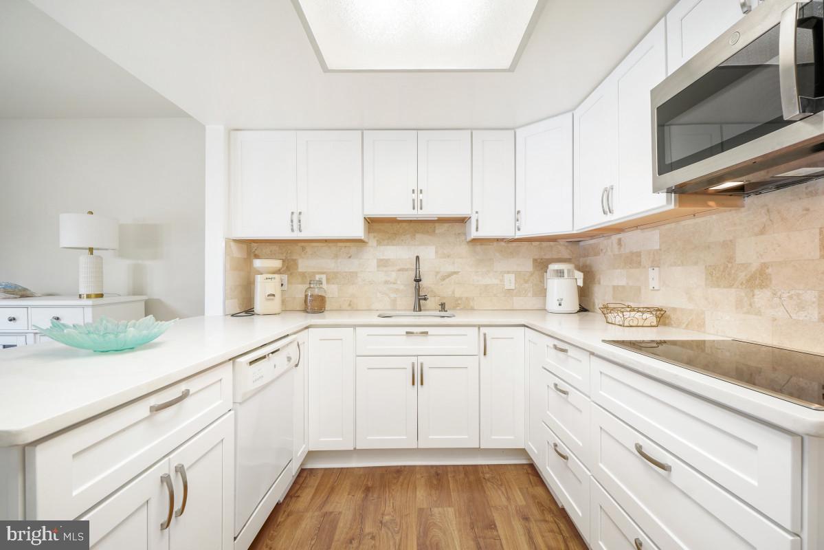 Welcome to resort-style living in this gated 55+ active adult community! This beautifully updated Montgomery Mutual Hampton model offers 2 bedrooms, 1 full bath, and an exceptional blend of comfort, style, and convenience. The remodeled kitchen features quartz countertops, a marble tile backsplash, luxury vinyl plank flooring, and quality cabinetry with soft-close drawers and doors. The updated bathroom is equally impressive with a quartz-topped vanity, soft-close cabinetry, and luxury vinyl plank flooring. Upgraded lighting throughout the home, including recessed lighting and illuminated bedroom closets, adds both style and functionality. Custom Hunter Douglas window treatments and freshly cleaned, plush carpeting and fresh paint complete the home's warm and inviting interior. The former balcony has been fully enclosed and transformed into a bright sunroom/sitting area off the living room, adding approximately 70 square feet of additional finished living space (approximately 5'11" x 11'10")—the perfect spot to relax, read, or enjoy your morning coffee. A full-size washer and dryer are also included. Additional features include abundant closet space, an assigned parking space, and a separate storage cage. The monthly fee includes both the co-op and HOA fees, all utilities, basic cable TV, Wi-Fi, property taxes, and most interior maintenance, providing exceptional value and peace of mind. Enjoy an outstanding array of community amenities, including two clubhouses, a fitness center, indoor and outdoor swimming pools, walking trails, tennis and pickleball courts, game rooms, restaurants, an 18-hole golf course, and countless clubs, classes, and activities. Surrounded by beautifully landscaped grounds, mature trees, abundant green space, and local wildlife, this community offers the perfect setting to enjoy an active, carefree lifestyle. Come experience all it has to offer!