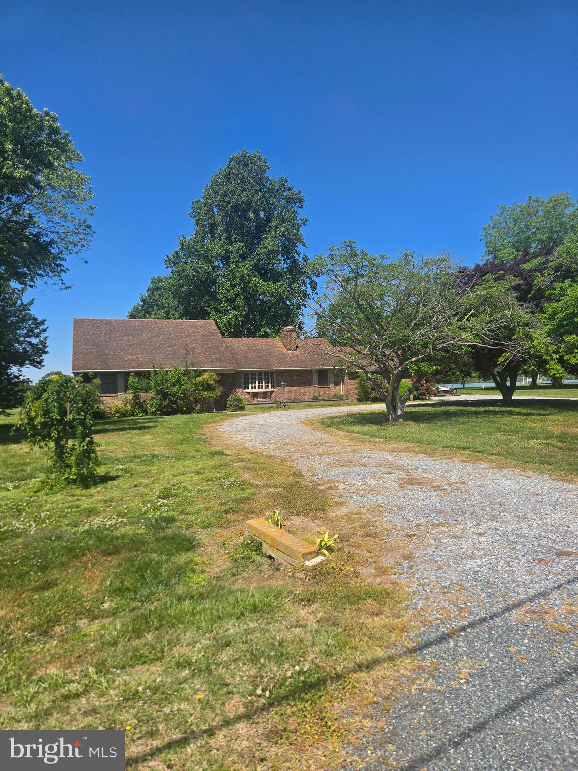 FIRST time being listed on the market with only one owner.  This waterfront brick rancher is situated on Fishing Creek and ready for its new makeover.  Enter into the spacious living room with brick wood burning fireplace and wood floors under carpet.  Kitchen has two pantries for storage, Laundry/Utility Room with washer and dryer, and three bedrooms downstairs.  Sunroom overlooking the water and an extra room going into the two-car attached garage as a bonus room.  Upstairs are two extra rooms to use as you'd like and a half bath.  Radiant heat in ceiling and mini ductless split for A/C.  Circular driveway and lots of flower gardens currently in bloom and an outside barn.  4' wide Pier and boat ramp make it perfect for boating, kayaking and all kinds of water sports.  Large back yard to enjoy family gatherings.  
Please see documents pertaining to well and septic and contact listing agent for any questions you may have.