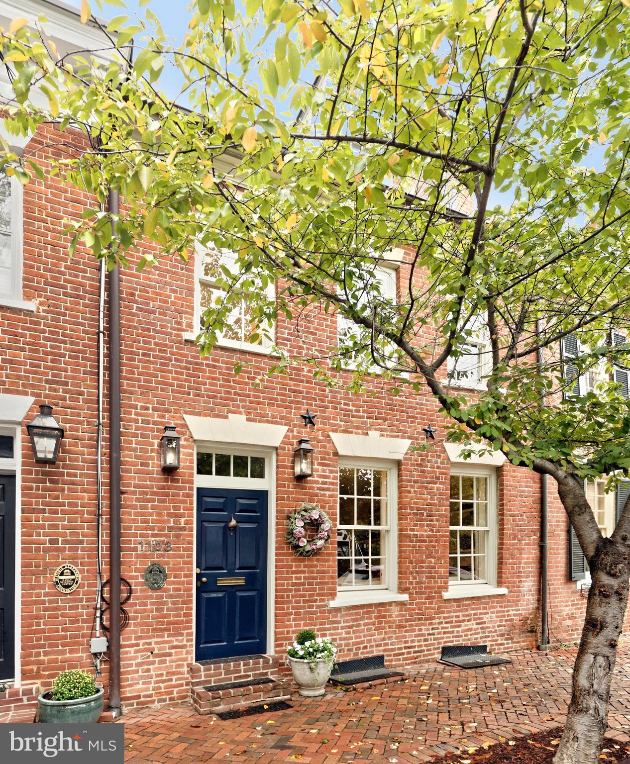 Circa 1804, this exceptional 3 bedroom, 2.5 bath home exudes historic charm with many original features including heart of pine floors, exquisite moldings, and exposed brick walls.  An incredible rear addition includes a fabulous open kitchen-family room and second floor primary suite. The formal living room is a masterpiece of design with built-in bookcases flanking a decorative fireplace, while the elegant dining room is graced by an antique chandelier that conveys.  At the heart of the home lies the gourmet kitchen equipped with honed marble countertops, top-of-the-line appliances, large island with seating, lighted display cabinetry, and a tall pantry.  It flows seamlessly into the spacious family room offering a cozy fireplace and custom built-ins provide both a bar and ample storage, creating a harmonious blend of functionality and style. French doors open to a private brick patio/garden with mature landscaping including boxwood, a Japanese Maple, climbing roses, and pansies.  Two staircases offer convenient access to the upper floors.  The second and third levels feature 3 skylights, 2 well-appointed guest rooms, and an updated bath.  A convenient laundry room boasts an LG washer/dryer plus a custom linen closet with lower file cabinet style drawers. The second-floor primary suite offers unparalleled comfort and style with vaulted ceilings, French doors opening to the Juliette balcony, wood-burning fireplace, Niermann Weeks chandelier, and a spa-like bath with a soaking tub plus a large seamless glass steam shower. Enjoy spending leisure time in the lower-level media/exercise room with wood paneling, exposed brick walls, and built-in seating. This home is a rare gem, offering timeless elegance and modern amenities in an ideal historic setting.  Architectural measuring verifies 2585 finished sqft.