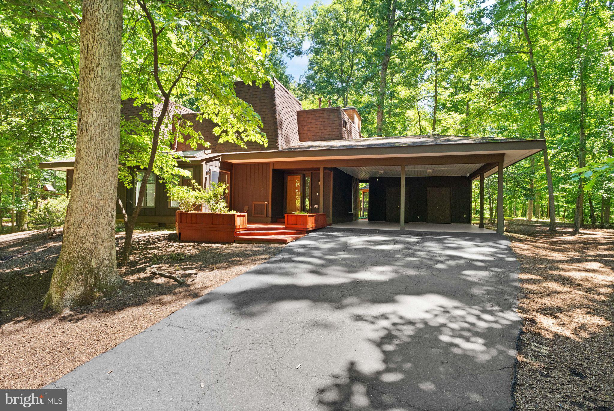 Welcome to this stunning contemporary home tucked away on a quiet cul-de-sac in the heart of Reston. Offering 4 bedrooms, 3 full baths, and 1 half bath across more than 2,800 finished square feet, this thoughtfully designed residence blends modern style, abundant natural light, and exceptional indoor-outdoor living.

Step inside to discover a dramatic two-story living room highlighted by soaring floor-to-ceiling windows, a striking gas fireplace, rich hardwood flooring, and custom built-in cabinetry. Fresh paint throughout the home creates a bright, move-in-ready feel. The open-concept layout flows seamlessly into the beautifully appointed kitchen featuring shaker-style cabinetry, granite countertops, stainless steel appliances, and ample workspace for everyday living and entertaining. The adjacent dining area is filled with natural light from skylights and expansive windows, creating an inviting space for gatherings.

The main level includes a spacious primary suite with private deck access, custom closet storage, and a spa-inspired ensuite bath featuring heated floors, dual vanities, a frameless glass shower, and direct access to the backyard retreat. Brand-new carpet adds comfort and style to the main-level bedrooms. A second generously sized bedroom, an additional full bath, powder room, and convenient laundry room complete the main level.

Upstairs, you'll find another bright bedroom, a versatile office or study space with custom built-ins, and an additional full bath, offering flexibility for guests, remote work, or hobbies.

Outdoor living shines with a private backyard oasis surrounded by mature trees. Enjoy relaxing or entertaining on the brick patio, gathering in the screened gazebo, or taking advantage of the expansive yard space. An extra-wide driveway and covered two-car carport provide ample parking and storage.

Ideally located near Reston Association amenities, residents enjoy access to pools, tennis courts, and more than 50 miles of scenic walking and biking trails just beyond the backyard. Convenient to shopping, dining, commuter routes, and all that Reston has to offer, this exceptional home combines privacy, comfort, and an unbeatable location. Don't miss this rare opportunity to make it yours.