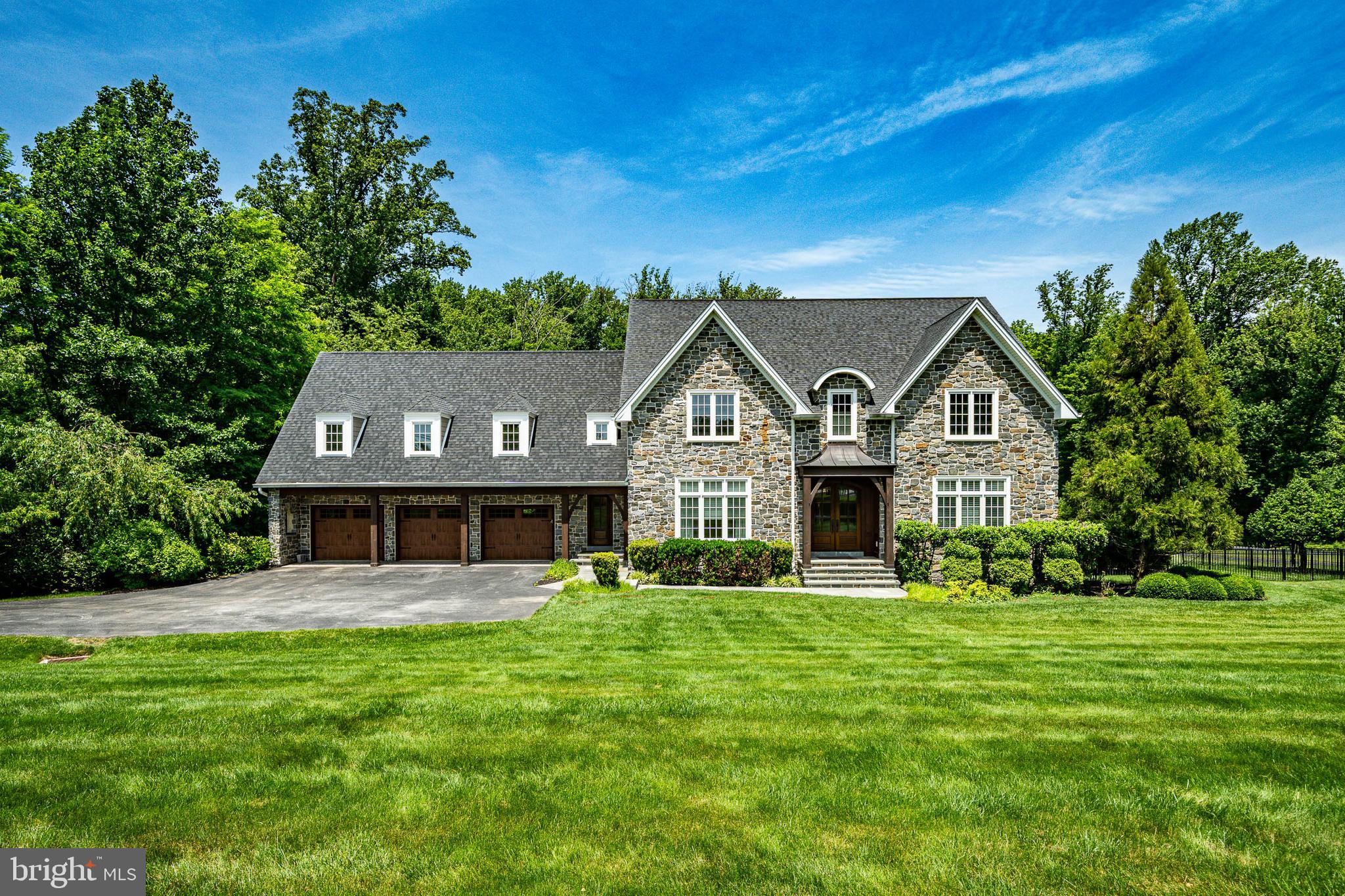 Welcome to this exceptional custom-built estate (2015) set on 2 acres across from Grace Winery, offering 5/6 bedrooms, 6 full and 2 half baths, and an extraordinary blend of luxury finishes, fine craftsmanship, and everyday comfort. Set on beautiful grounds, on a quiet tree-lined street, complete with a sparkling pool, expansive play area, and oversized deck, this home was designed for both elegant entertaining and relaxed family living.
A stunning exterior showcases stone construction, accented by Douglas fir timber-frame beams and posts, solid mahogany double door entry, and a welcoming covered entrance with flagstone walkway. Inside, soaring ceilings, large windows, random-width site-finished hardwood floors, arched entryways, beautiful moldings, and an open floor plan create a bright and inviting atmosphere throughout.
The heart of the home is the spectacular gourmet kitchen featuring marble and granite leathered countertops, a Sub-Zero refrigerator, Wolf commercial range, oversized walnut center island, enormous walk-in pantry, and seamless flow into the sun-filled breakfast room and spacious family room with a gas fireplace and marble surround mantle, and custom built-ins.  A gracious formal dining room provides the perfect setting for holiday gatherings and special occasions, while a spacious living room, currently used as a living room, offers exceptional flexibility. With an adjacent full bath, this space could easily serve as a main-floor bedroom suite for guests, in-laws, or multigenerational living. Upstairs, the luxurious primary suite is a true retreat, offering a dramatic entry to a spacious bedroom, custom outfitted walk-in closet complete with center island, and a spa-inspired marble bath featuring an extra-large frameless glass shower, soaking tub, heated marble floors, a custom-designed dual sink vanity with cabinet tower, and a private water closet. An en-suite bedroom includes its own custom outfitted walk-in closet, with luxurious bath including a custom tile surround walk-in shower.  Two generously sized bedrooms share a Jack-and-Jill bath with tub shower combo and double vanity.  While the enormous fifth bedroom at the opposite end of the hallway has its own bath and provides incredible flexibility as a guest suite, recreation room, playroom, or nanny suite. The laundry room with built-ins is in this area as well.
The expansive finished third floor with a half bath serves as an ideal home office and lounge but can easily adapt to a variety of needs including a fitness studio, creative space, additional bedroom, or private retreat.
Designed for entertaining, the fully finished daylit, walk-out, lower level features a tiled recreation room, media space, kitchen, a full bath, and a second laundry room. The lower level has french doors accessing the pool area, a screened-in porch, and incredible outdoor living spaces, making it the ultimate venue for hosting family and friends. The lower level has a fantastic recreation area, media room, guest quarters, or pool house extension; the possibilities are endless.  Outside, find a gas firepit for chilly evenings while sipping wine or roasting s'mores, a sparkling pool with a hot tub and fountain, and the ever-popular twisty water slide! 
Additional highlights include a tiled mudroom with a bench seat and a powder room with convenient access to the 3-car garage, and abundant storage. The most discerning buyer will appreciate the exceptional quality, attention to detail throughout, the thoughtful design, and expert craftsmanship that define this remarkable residence.
Perfectly situated directly across from the picturesque Grace Winery & Vineyard, this exceptional property combines a private estate setting with unmatched convenience. Located within the award-winning West Chester Area School District and just minutes from major commuter routes, shopping, dining, and everyday amenities, this home offers the best of Chester County living.