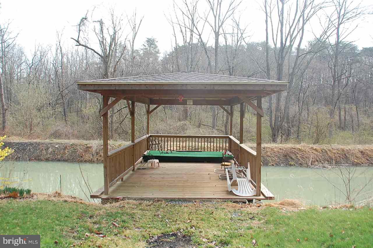 Don?t miss this beautiful 18.19 acre completely wooded tract of land. This property features a 2 + car garage including 2 open storage bays on either side of the garage, a pond which features a covered dock, and a stream running through the property.  This property is perfect for hunting and other recreational uses.