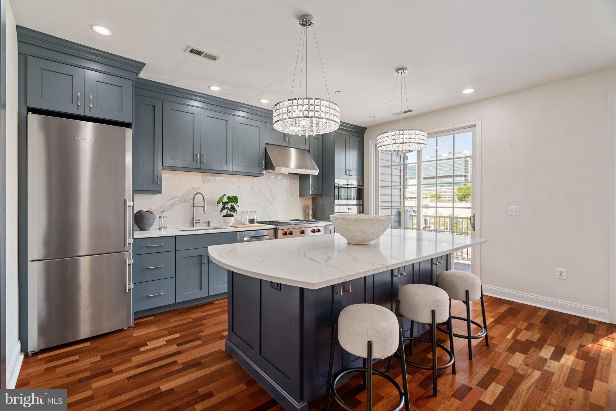 Ideally located in a prized, gated enclave just south of Fitler Square, and only steps to University City, this completely renovated Naval Square home is exactly what you have been waiting for! 406 Regatta Drive is an exquisite bi-level townhome boasting 3 bedrooms, 2.5 baths and a deeded parking space!  As you step inside, you'll immediately notice the care and dedication the owners have put into both renovating and maintaining this lovely home. The location of 406 is prime— uniquely positioned and nonadjacent to other townhome buildings — this home offers unmatched privacy and seclusion, in addition to affording it an abundance of natural light!  On the first level, you will be welcomed into a spacious open concept living/dining area with gorgeous Brazilian cherry hardwood flooring and an abundance of recessed lighting.  Next, flow seamlessly into the exquisitely designed kitchen by the award-winning team at Ferrarini & Co., where elevated design meets uncompromising functionality. This truly luxurious culinary space is outfitted with a double Wolf convection oven and a 36-inch Wolf range, complemented by dual Bosch dishwashers and Liebherr & Fisher and Pykel refrigerators —perfectly suited for both everyday living and effortless entertaining. Additional highlights include a sleek microwave drawer and a statement hood, seamlessly integrated into the design. Sleek quartz countertops, custom ceiling-height cabinetry, and a built-in wine refrigerator complete this beautifully appointed, high-design kitchen. The adjoining family room is full of sunshine, and opens to a private terrace spanning the full length of the property. The spacious terrace embraces the University City skyline and a stunning vantage of the nearby Roberts Center. On the second level, retreat to an elegant primary suite defined by soaring vaulted ceilings, thoughtfully crafted custom built-ins, and a spacious WIC. The fully renovated ensuite bath offers a refined, spa-like experience, featuring dual vanities with quartz countertops and a generously sized shower enclosed in sleek frameless glass. On this level, you will also find two additional sunlit bedrooms with more custom built-ins, an additional updated bath, and laundry closet with newer side-by-side LG washer & dryer. A spacious entry-level storage closet offers exceptional versatility, complete with built-in shelving to accommodate everything from strollers and luggage to seasonal décor and everyday essentials. Have a large SUV? You’ll appreciate the ease of a spacious, pull-in deeded parking space (P-397), conveniently located just steps from your front door. Have peace of mind knowing that the hot water heater was replaced in 2024 and both HVAC units have been serviced in 2025. Smart home features include: August Lock & Nest Thermostats. Enjoy the ease of a heated outdoor pool and a state-of-the-art fitness center just steps from your door, complemented by nearby concierge services for added convenience. The dramatic community room in the Biddle Hall rotunda is perfect for hosting private parties. Take advantage of the outdoor amenities in the 20-acre, park-like setting, including picnic areas, well-kept gardens, and mature landscaping. With a gated entry and on-site visitor parking, convenience and security are paramount. Residents also benefit from on-site Amazon lockers and electric vehicle charging stations. The property is also located in very close proximity to the South Street Bridge, UPenn (0.7 mi), CHOP, HUP, Drexel, Rittenhouse (0.9 mi), and Fitler Square.Fantastic restaurants and cafes, such as Rival Bros, Friday Saturday Sunday, Illata, Pub & Kitchen, Sabrina’s, and Loco Pez, are nearby & the Heirloom Market is only a block away. Out the back gate, you’ll find easy access to Schuylkill River Park & Playground and dog park!