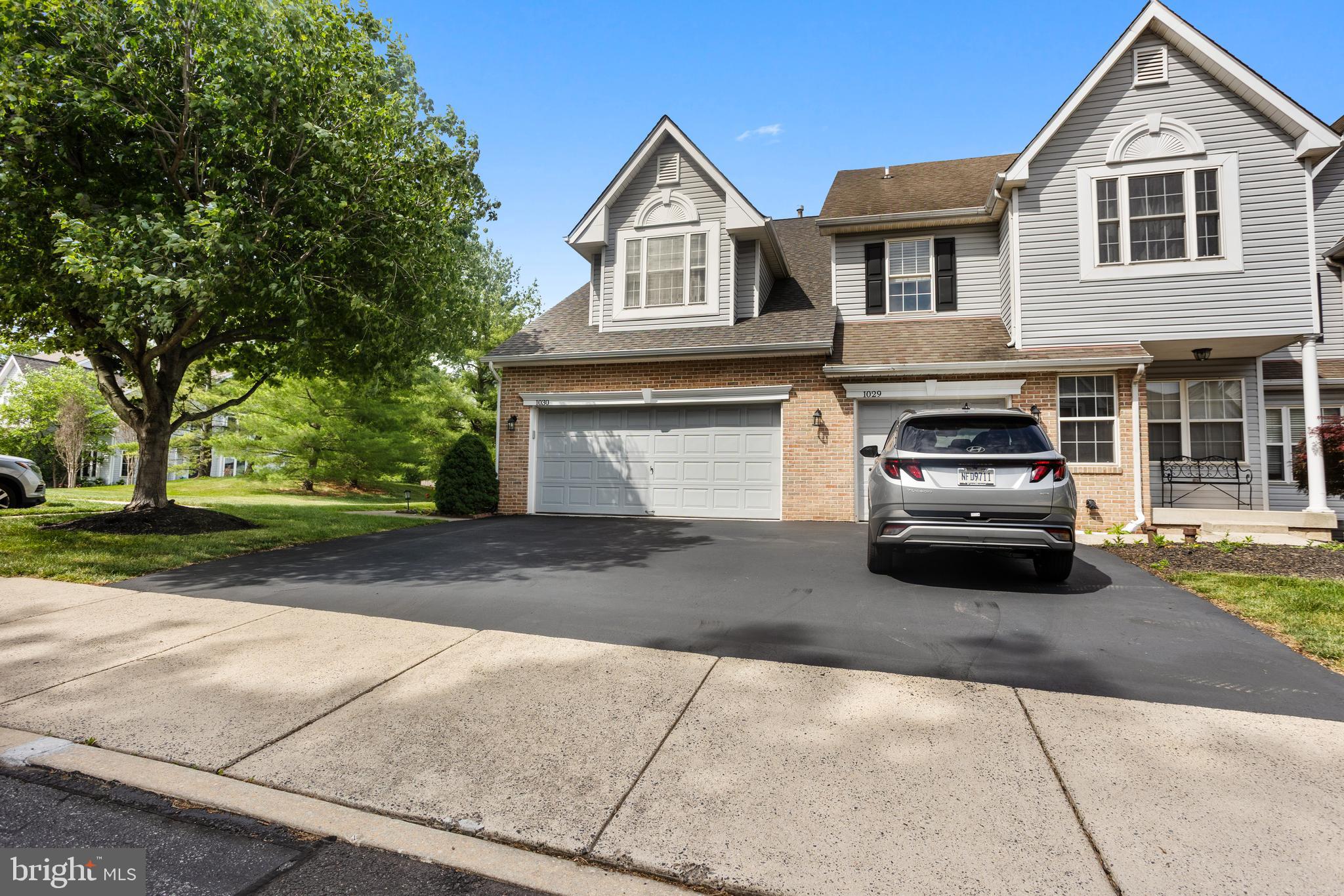 Welcome to 1030 Greenes Way Circle in Collegeville — a beautifully updated 3-bedroom, 2.5-bath end-unit townhome in the desirable Providence Greene community within the highly regarded Methacton School District. Offering over 2,000 square feet of finished living space plus a fully finished basement, this home provides the perfect blend of comfort, style, and functionality.
One of the standout features is the rare two-car garage — available in only a select number of homes within the neighborhood — along with a large driveway and two convenient overflow parking lots located on both sides of the property.
The recently updated kitchen (2022) is sure to impress with quartz countertops, gray cabinetry, beautiful backsplash, stainless steel appliances, and a bright breakfast nook area. The adjoining family room features a cozy gas fireplace, creating the perfect gathering space. The main level also includes a separate dining room and living room, while the updated powder room showcases new flooring, lighting, and toilet. Fresh paint throughout the home gives it a clean, modern feel.
Upstairs, the spacious owner’s suite offers cathedral vaulted ceilings, a ceiling fan, and dual walk-in closets. The beautifully renovated owner’s bath (2022) features quartz countertops, tiled flooring, and a stunning walk-in shower. Bedroom 2 includes a walk-in closet and ceiling fan, while bedroom three also offers a ceiling fan. The hall bathroom has been refreshed with a new toilet, updated tub doors, and a single vanity.
The laundry room includes cabinetry, utility sink, and newer washer and dryer — both included with the home, along with the refrigerator.
The basement level offers additional finished living space, multiple closets for extra storage, and a large unfinished storage area — providing the perfect setup for a home office, gym, playroom, media room, or flexible living space to fit your needs. Additionally, the oversized two car garage has been upgraded with insulation, finished drywall and painted walls and floors – creating a clean, polished space that is perfect for parking, storage, a workshop area, or home  gym setup.
Additional major updates completed within the past few years include:
**New heater and air conditioner 2018.  
**50 gallon hot water heater 2024.  
**Roof replacement 2020.  **New garage door opener .  Residents of Providence Greene enjoy outstanding community amenities including a pool, tennis courts, basketball courts, walking paths, and trash service included in the monthly association fee.
Ideally located near shopping, dining, and major highways, this home offers the convenience you need while being tucked inside a quiet sidewalk-lined community with wider streets and amenities for all ages.