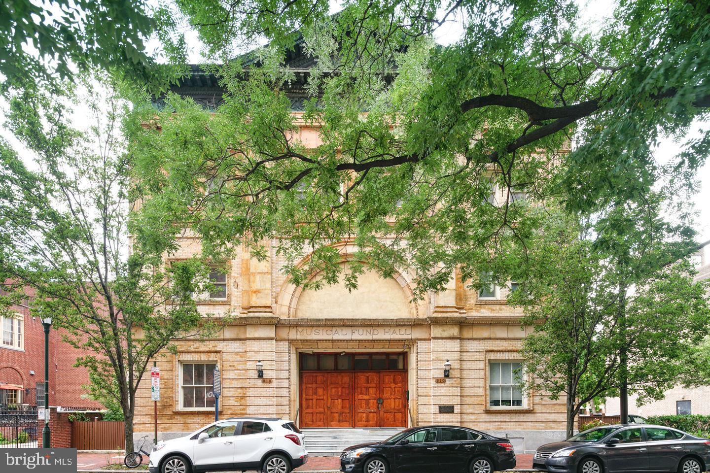 Experience the perfect blend of historic grandeur and contemporary luxury in this exceptional bi-level condominium, ideally situated at 802 Locust Street in the heart of Washington Square West. Offering 3 bedrooms, 2.5 baths, and coveted deeded parking, this remarkable residence combines sophisticated design with an unbeatable Center City lifestyle.

From the moment you enter, you'll be captivated by the dramatic 28-foot soaring ceilings, expansive floor-to-ceiling windows, and an abundance of natural light that fills the home throughout the day. The impressive open-concept living and dining area is anchored by a striking fireplace, creating a warm yet elegant setting for both everyday living and entertaining.

The chef-inspired kitchen is thoughtfully designed with rich espresso-stained solid wood cabinetry, polished granite countertops, a glass subway tile backsplash, stainless steel appliances, and a spacious center island with seating for four. The adjacent dining area seamlessly accommodates intimate dinners and larger gatherings alike.

The main level also features two generously sized bedrooms, a full bath, a powder room, and a conveniently located laundry area. Upstairs, the private primary suite serves as a luxurious retreat, complete with custom-fitted closets and a beautifully appointed en-suite bath featuring a dual vanity, designer tilework, and a frameless glass shower.

A versatile loft area overlooks the living space below and offers endless possibilities as a home office, media lounge, fitness area, or creative studio. Just beyond the primary suite, an additional flex space provides the perfect private office, reading room, or dressing area, with direct access to attic storage rarely found in Center City condominiums.

Located within the highly sought-after McCall School Catchment and just steps from Washington Square Park, some of Philadelphia's finest restaurants, boutique shopping, cultural attractions, Jefferson and Pennsylvania Hospitals, and convenient public transportation, this residence offers an unparalleled opportunity to enjoy luxury living in one of the city's most desirable neighborhoods.